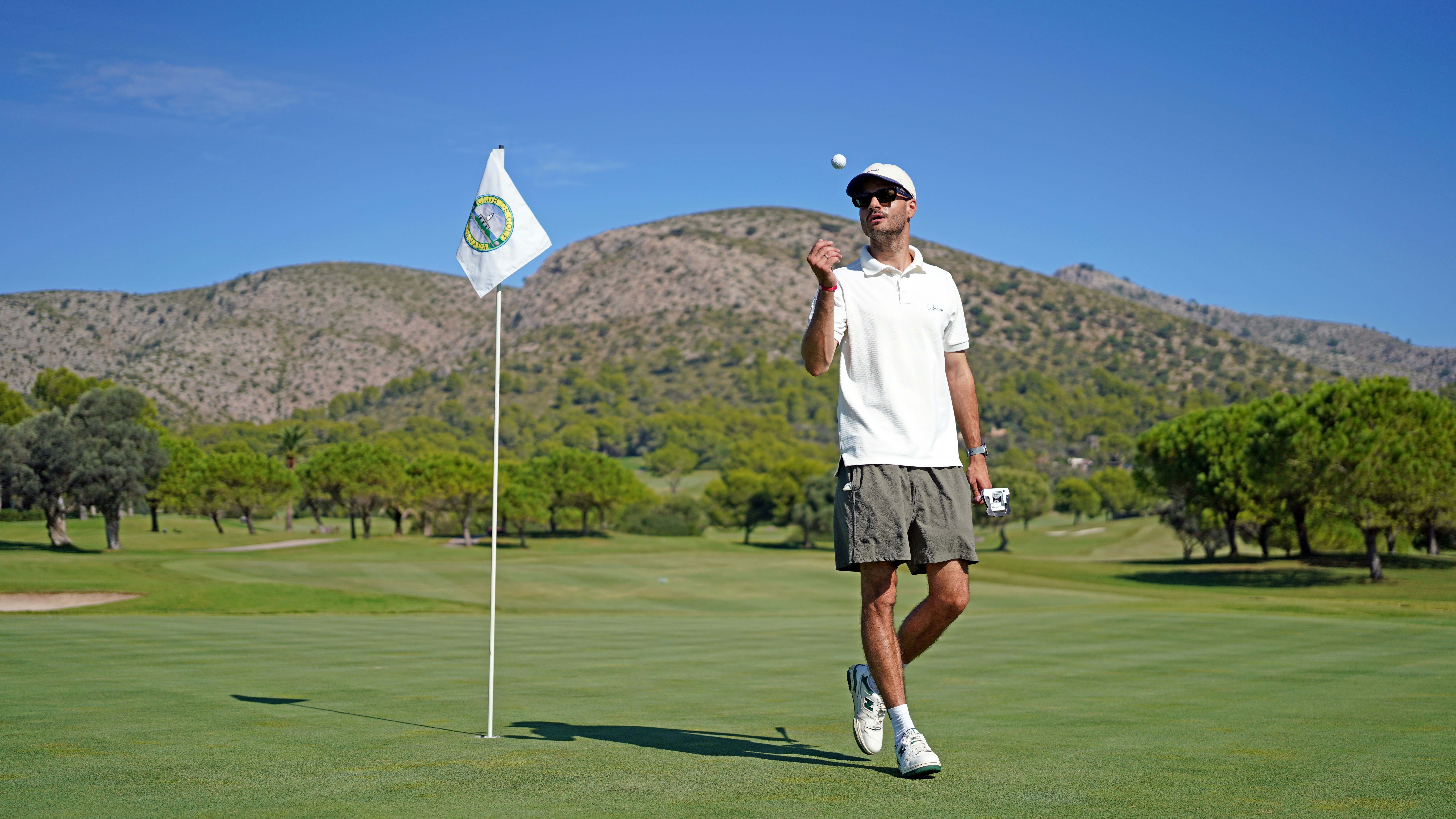 A man standing on top of a green golf course