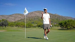 A man standing on top of a green golf course