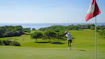 A person on a golf course with a flag