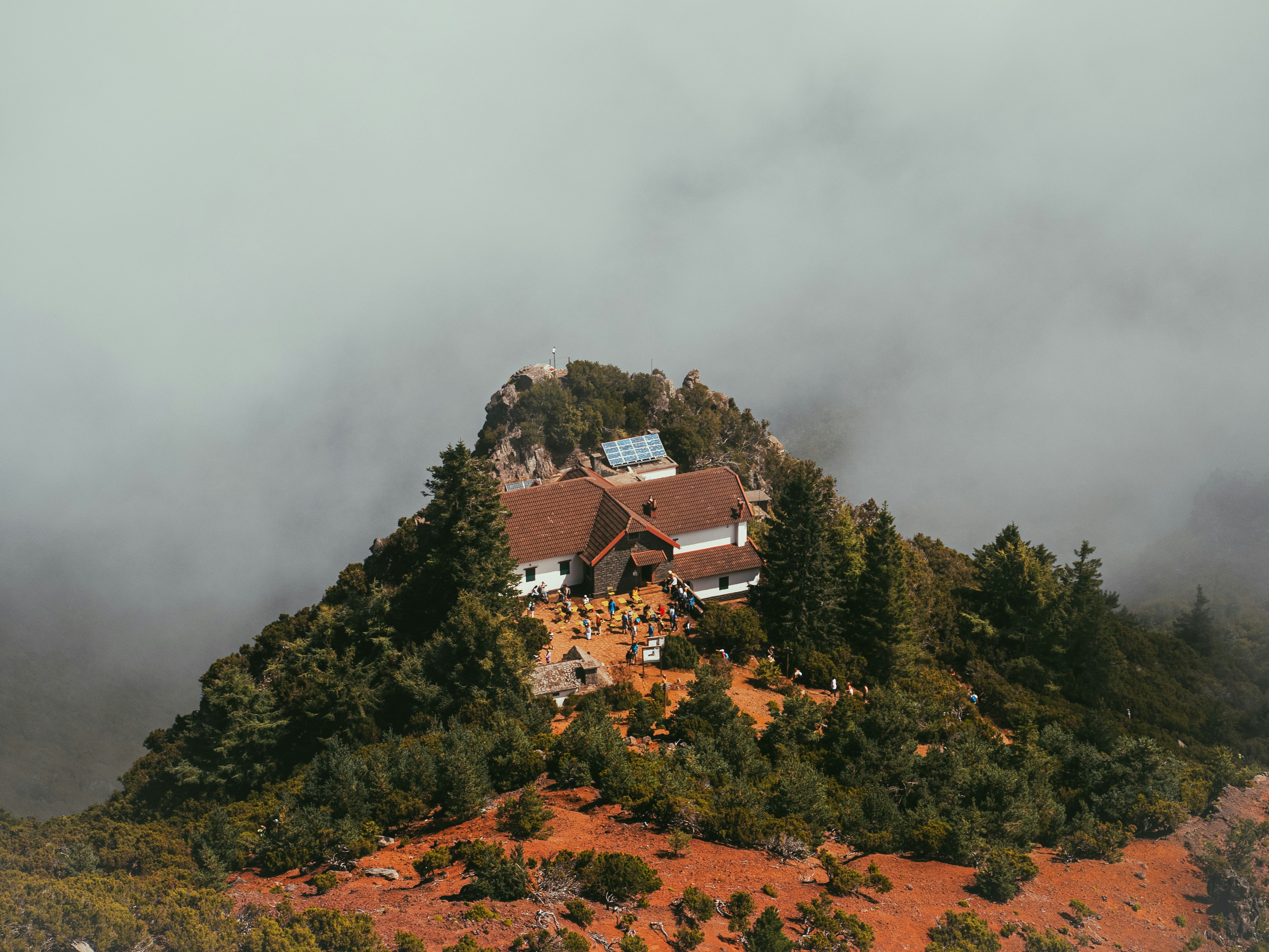 A house sitting on top of a mountain surrounded by clouds