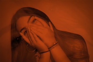 A woman covering her face with her hands