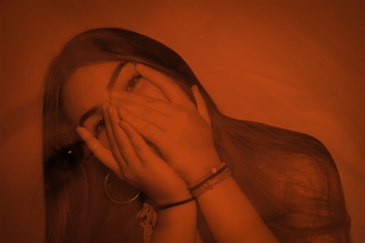A woman covering her face with her hands