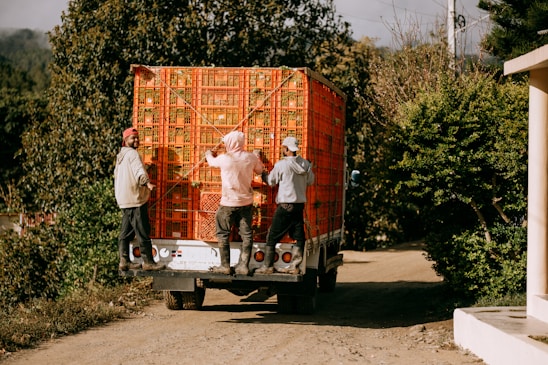 A group of people unloading a large box on the back of a truck