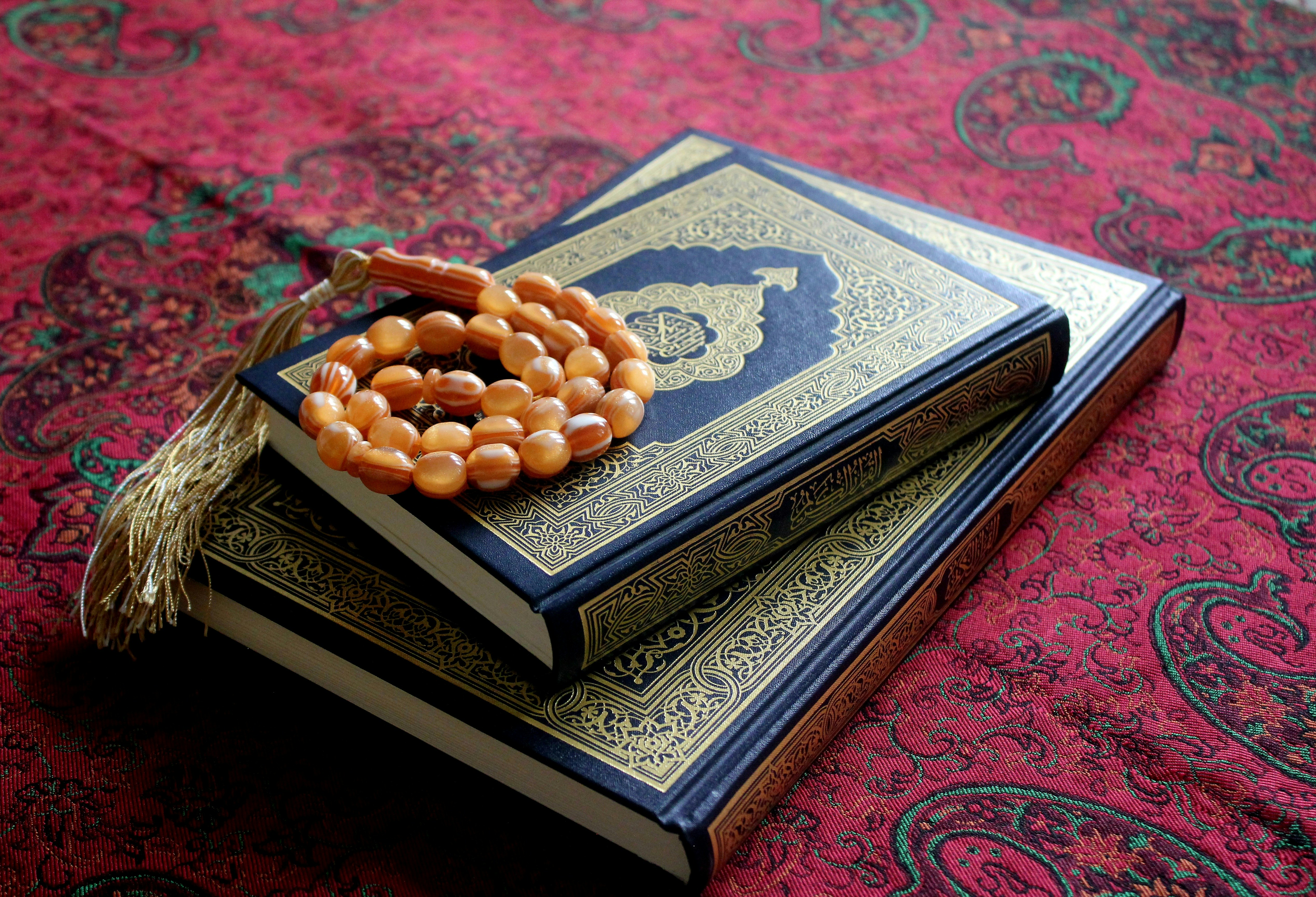 A stack of three books with beads on top of them