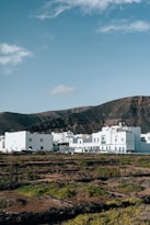 A group of white buildings sitting on top of a lush green field