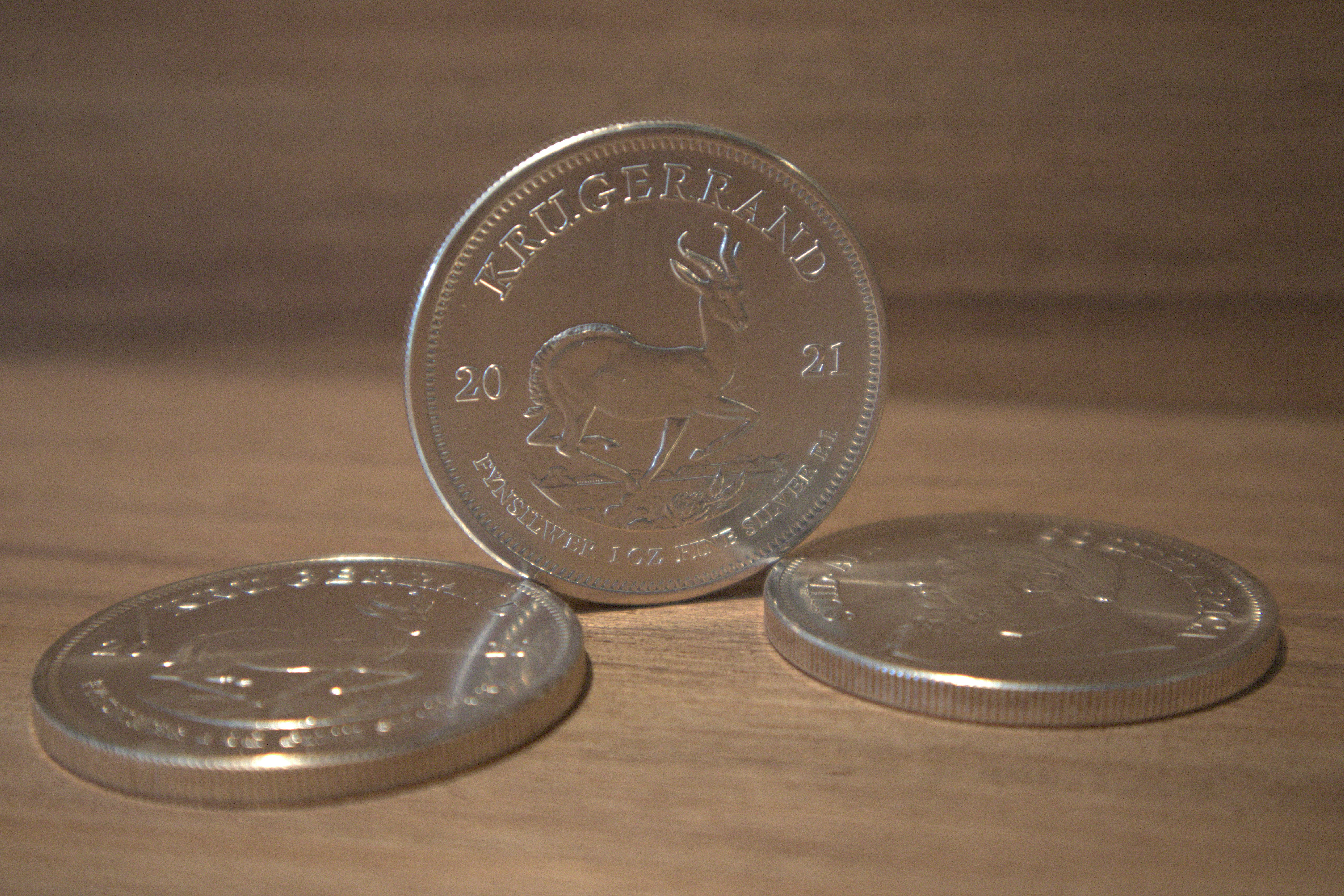 Close-up of Krugerrand coin face showing Springbok, bright studio lighting