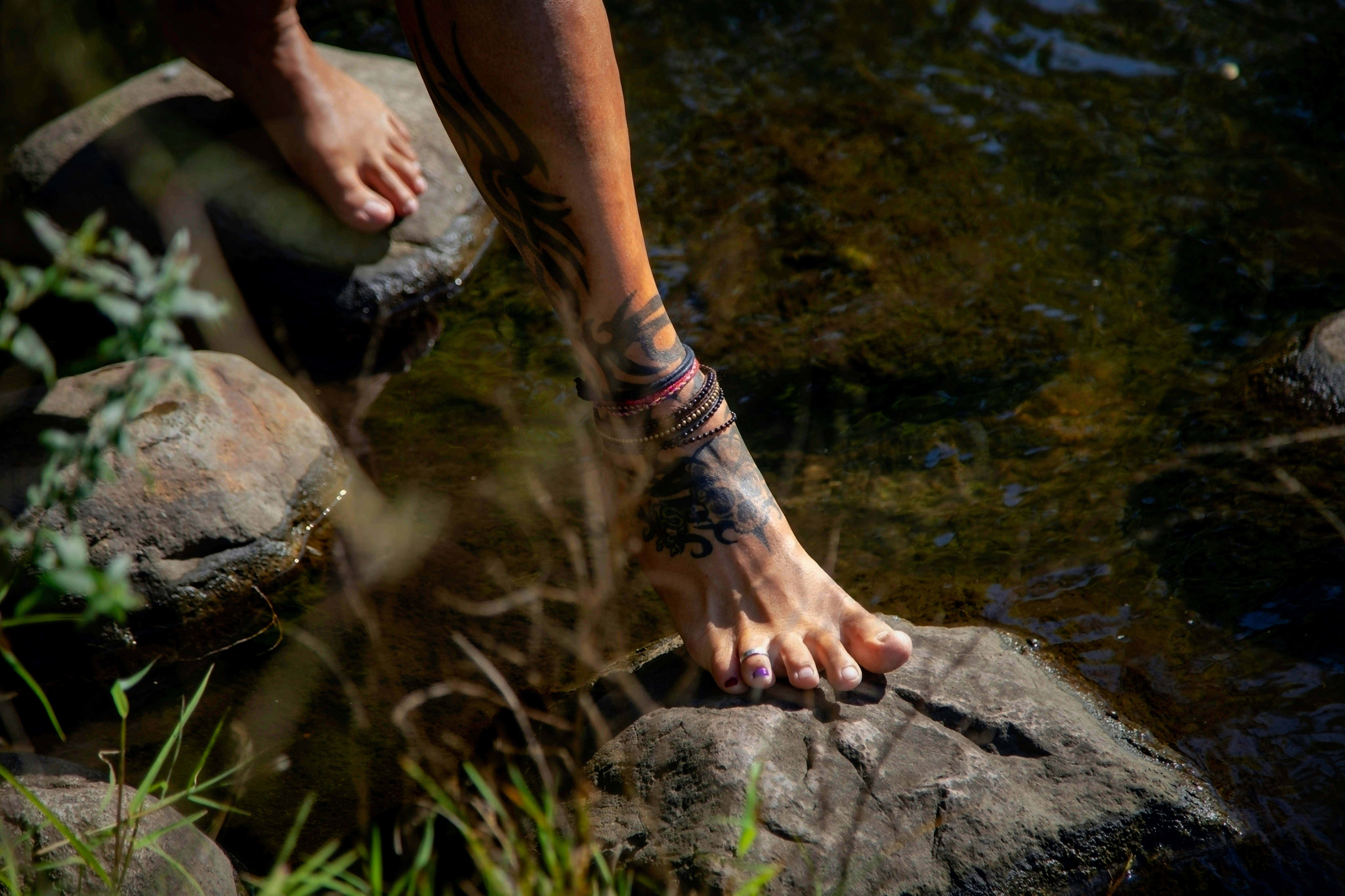 A person standing on top of a rock next to a body of water