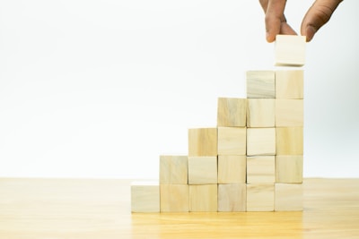 A hand is placing a block into a pyramid