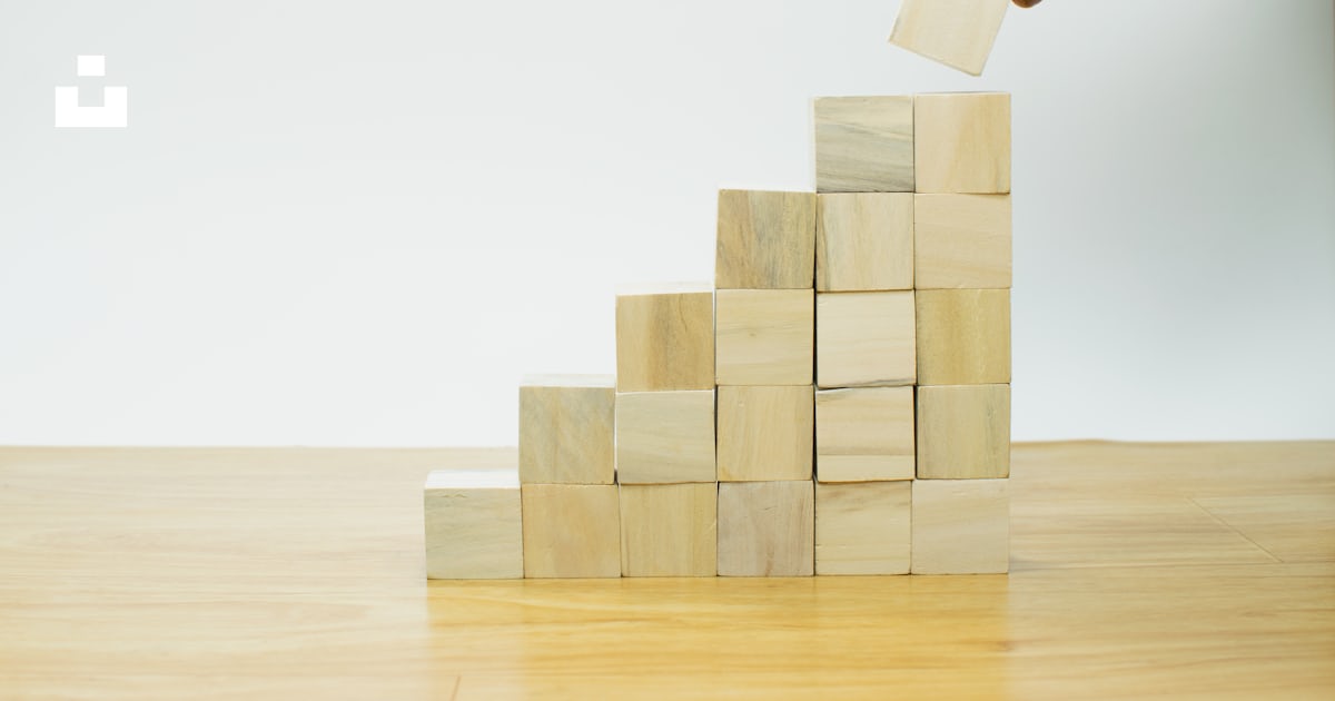 A person placing a piece of wood into a pyramid photo – Free Steps ...