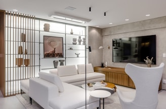 A living room with a white couch and a white chair