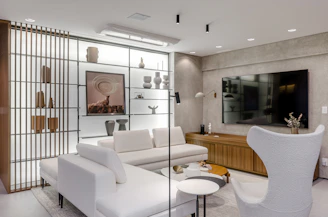 A living room with a white couch and a white chair