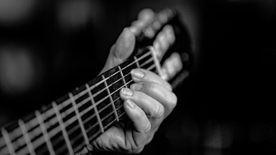 A black and white photo of a person playing a guitar