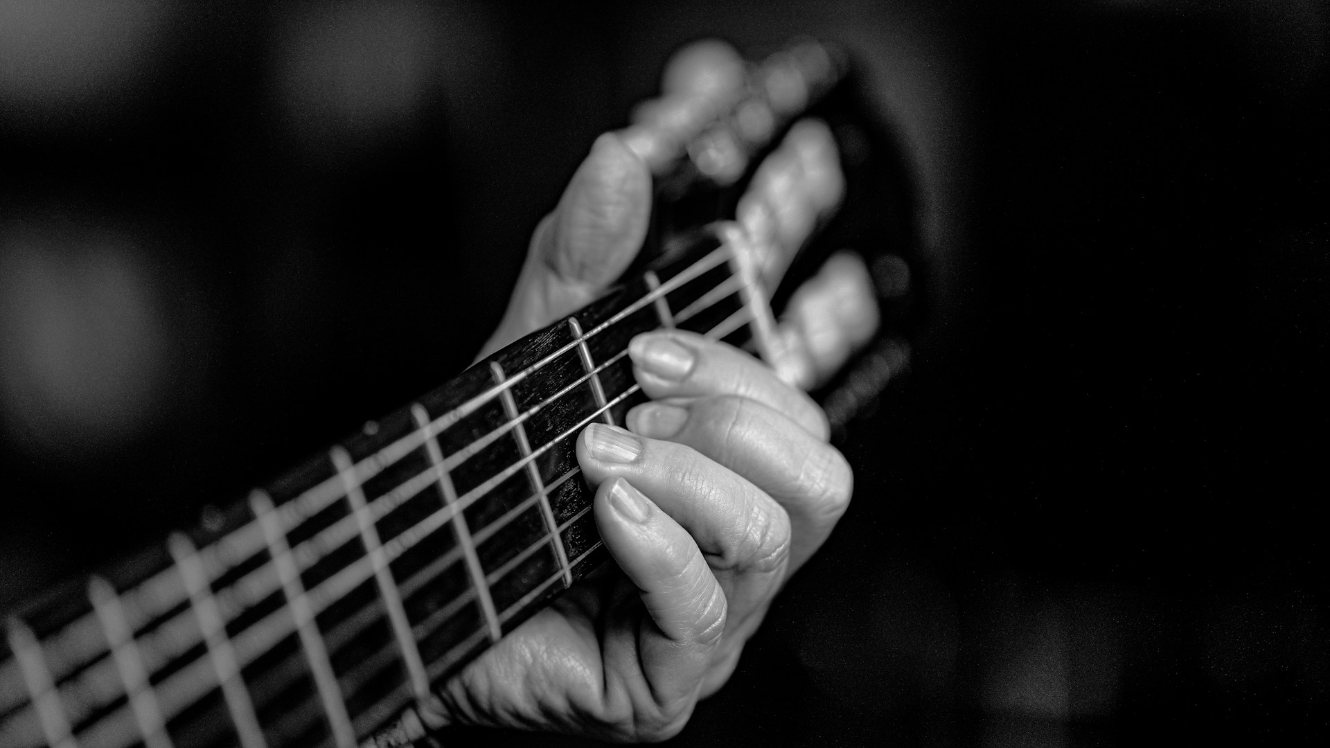 A black and white photo of a person playing a guitar
