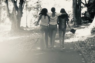Three women walking down a path in the woods
