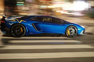 A blue sports car driving down a city street on high speed with good performance tyres