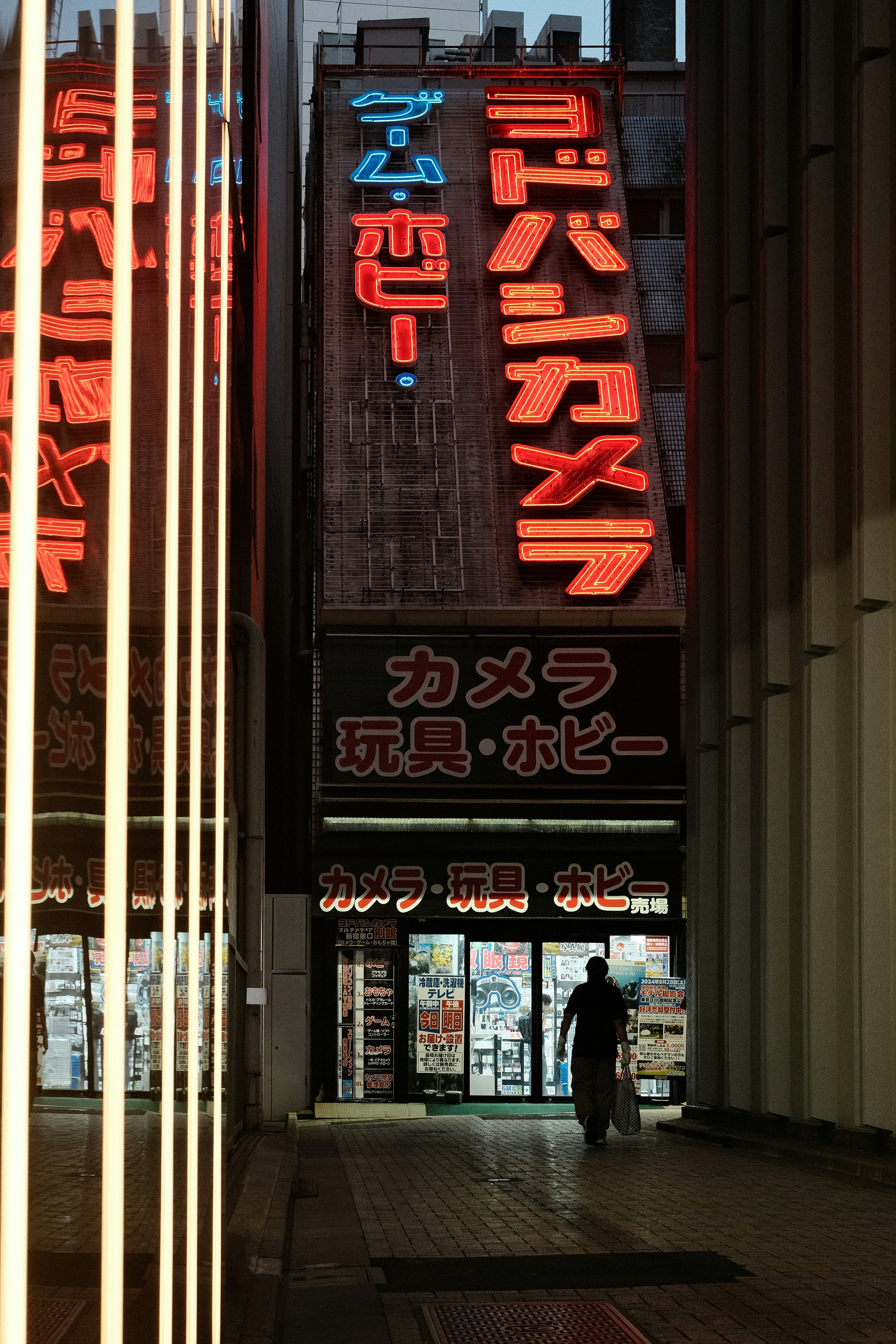 A man walking down a street next to tall buildings