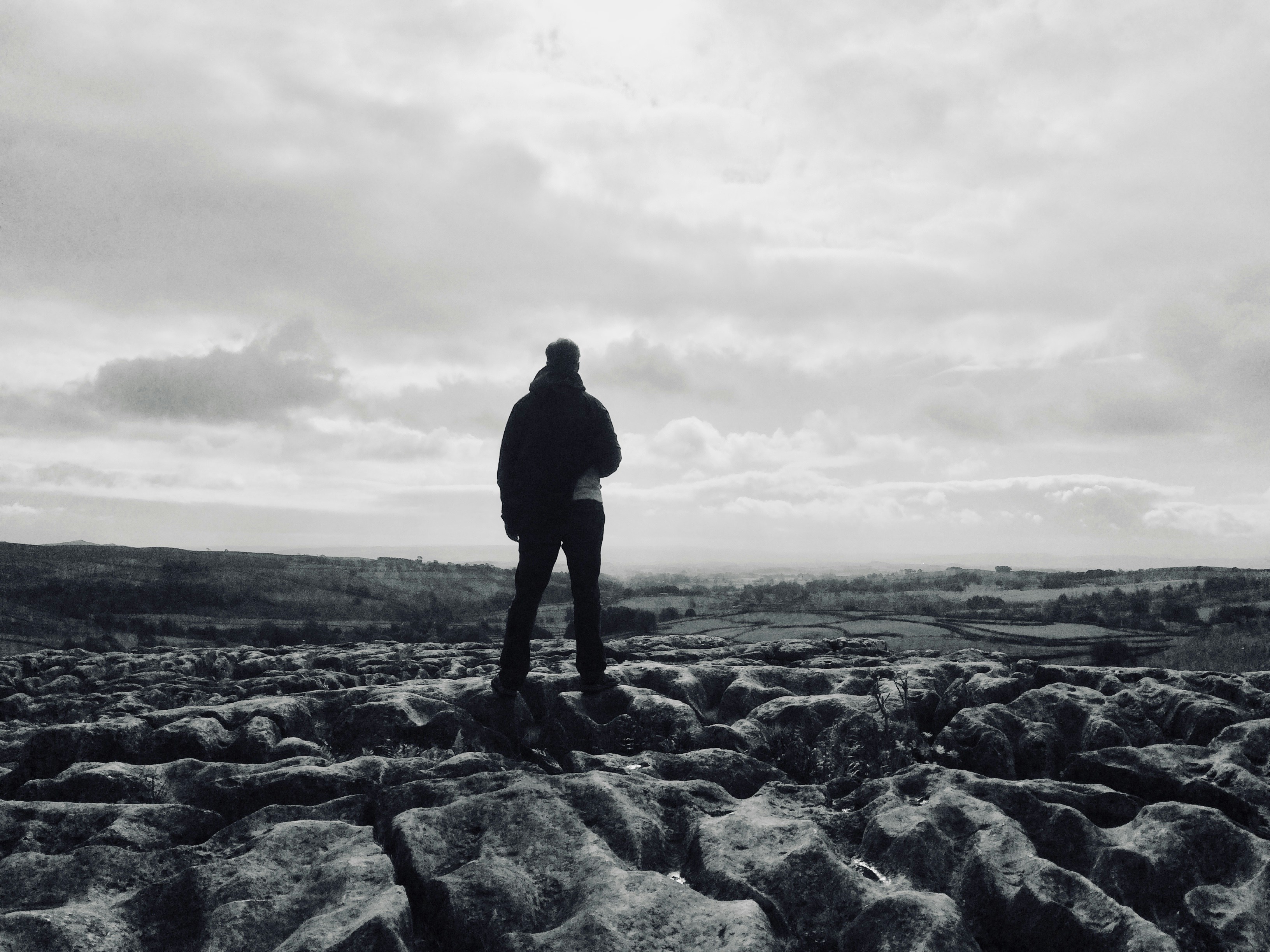 A man standing on top of a rock covered field