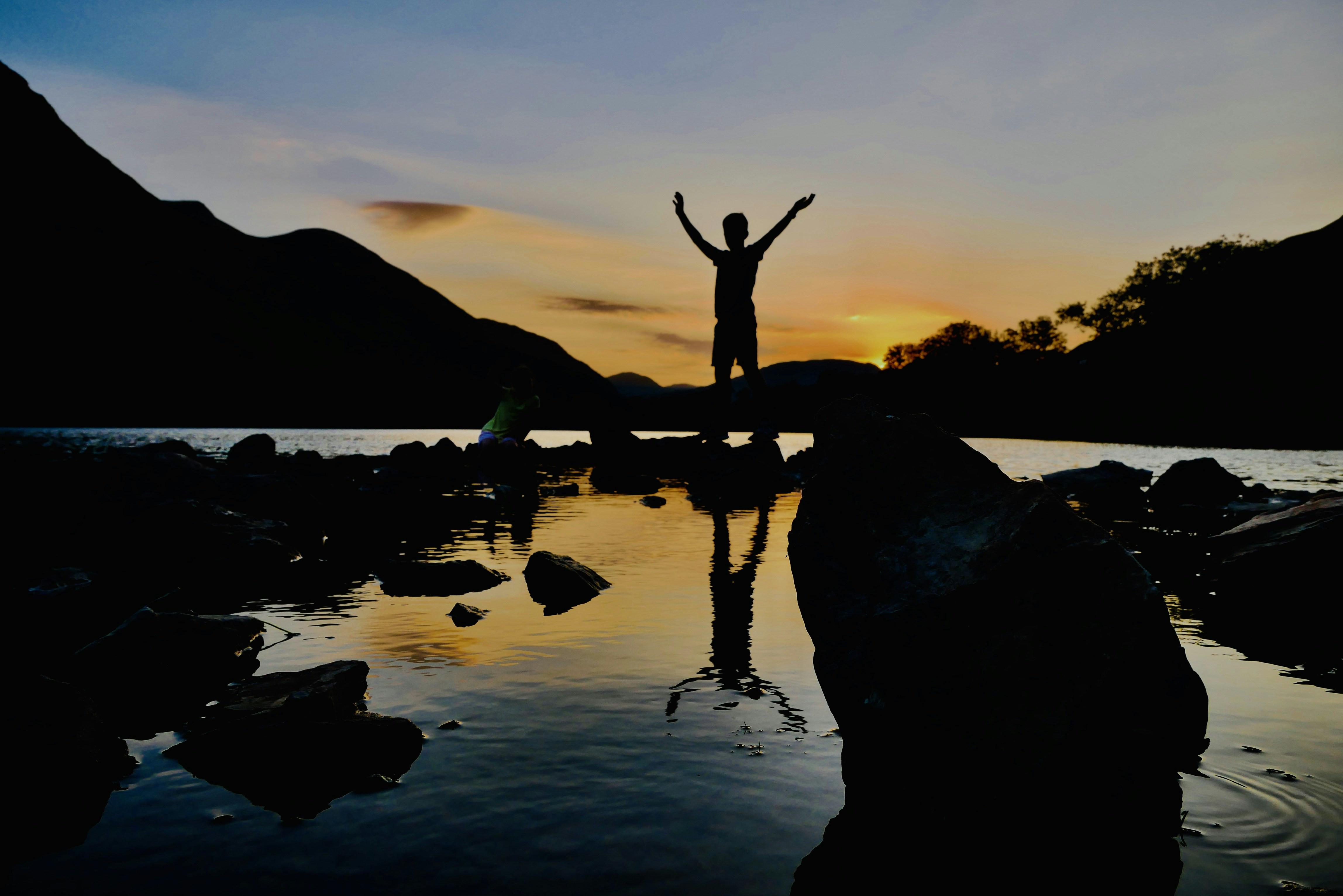 A person standing in the water with their arms in the air