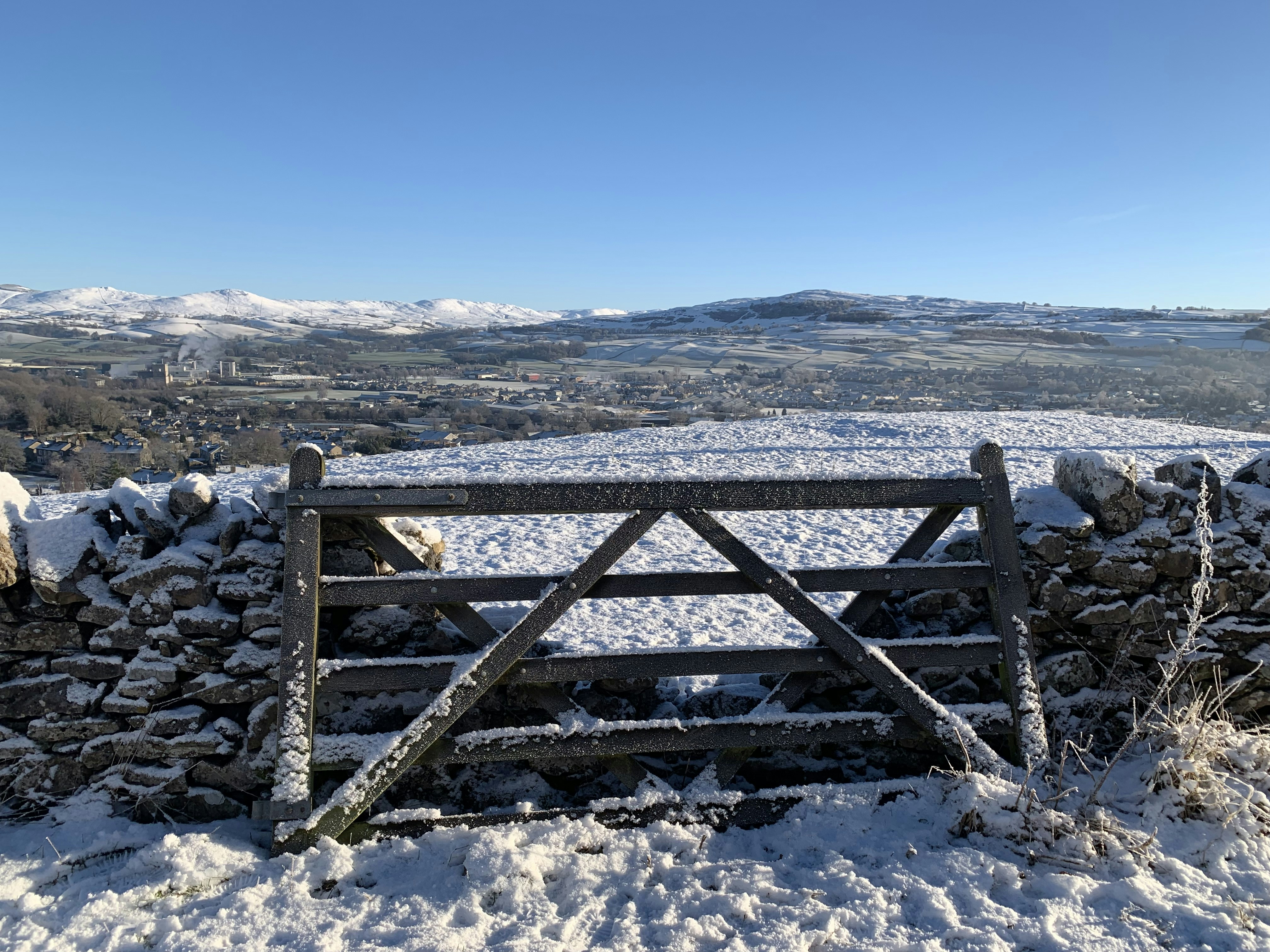 A wooden gate in the middle of a snowy field