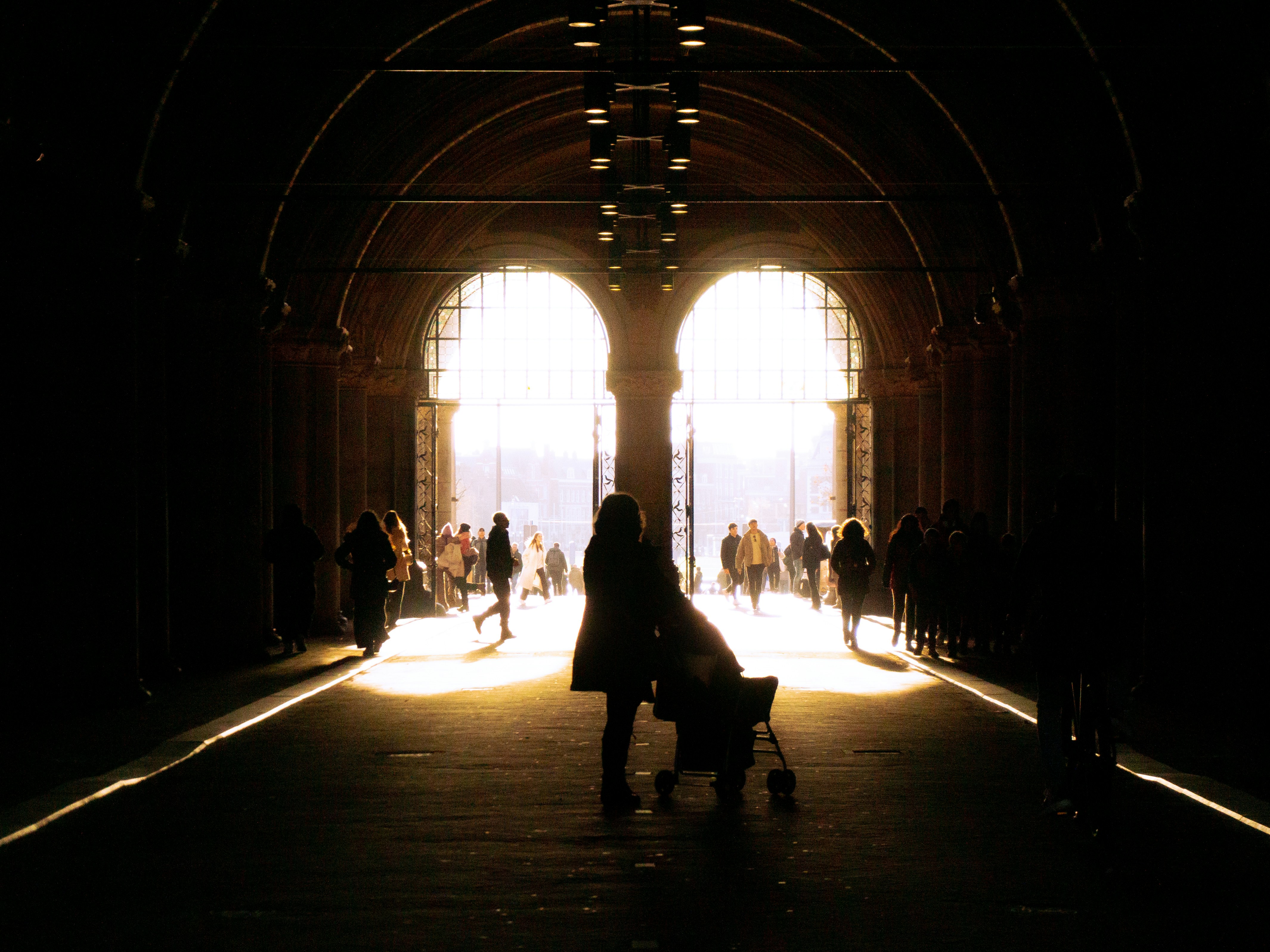 Eine Person mit einem Kinderwagen in einem dunklen Tunnel