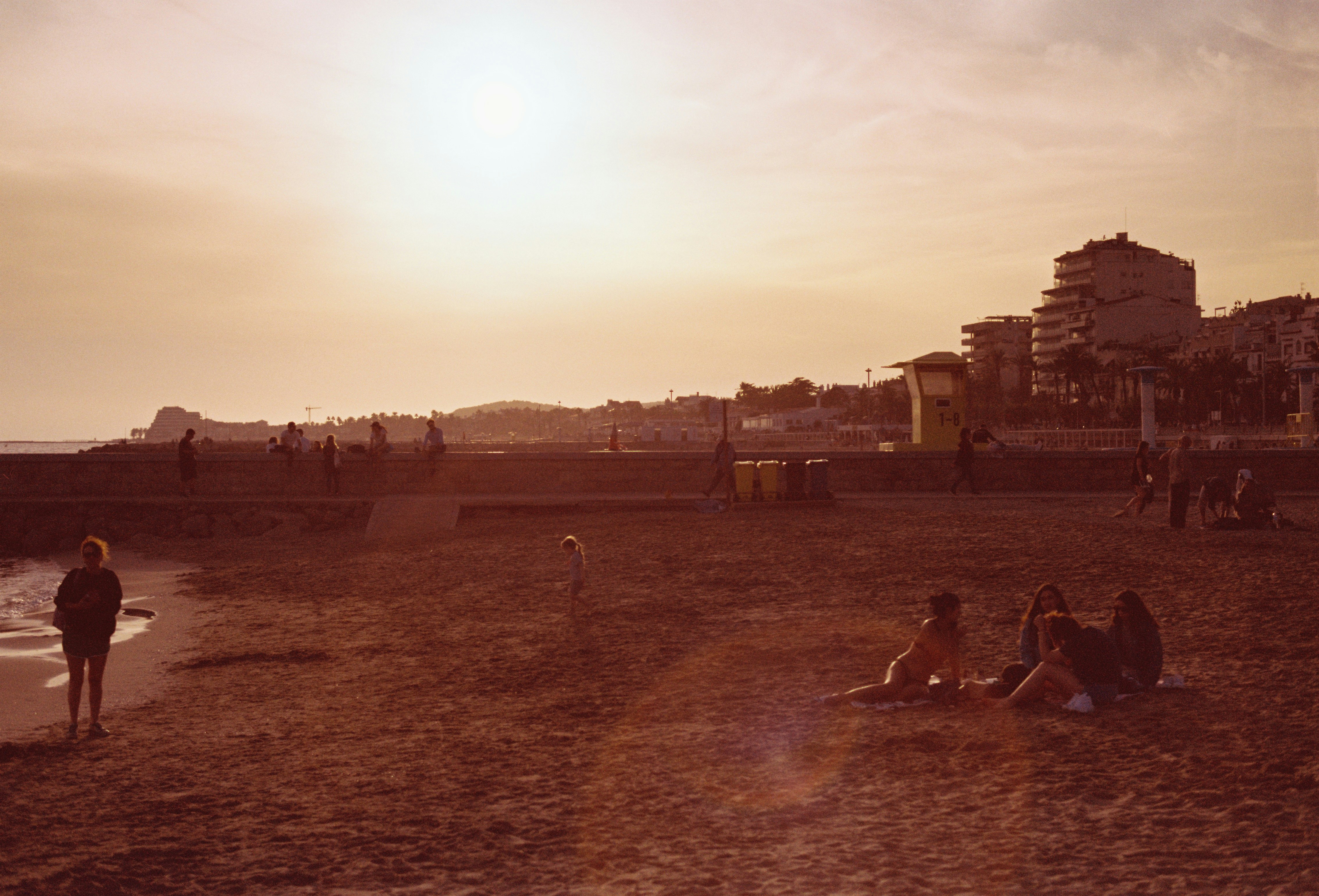 A group of people sitting on top of a sandy beach
