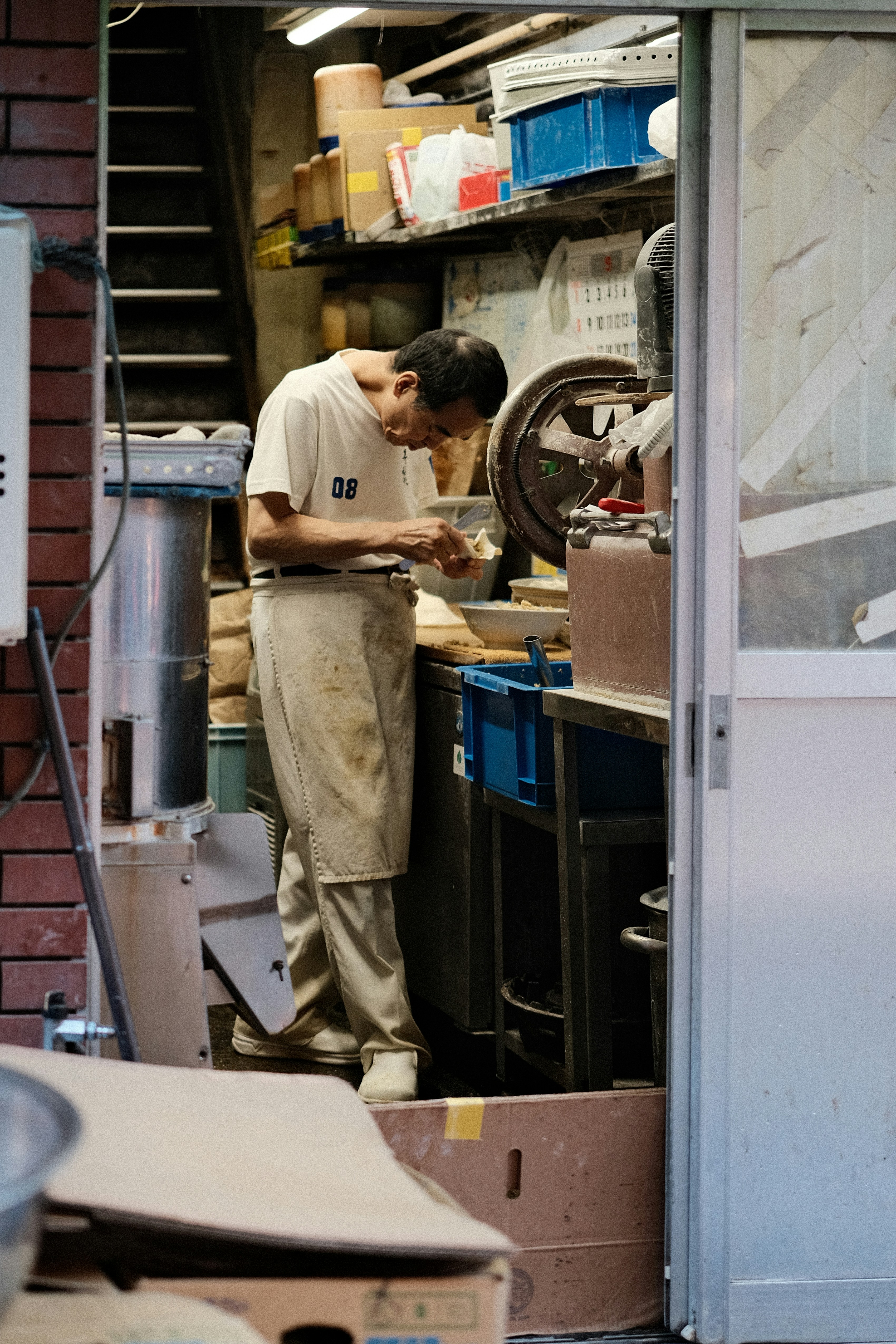 A man standing in a kitchen next to a brick wall