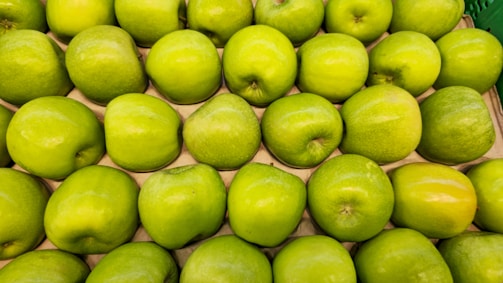 A pile of green apples sitting next to each other