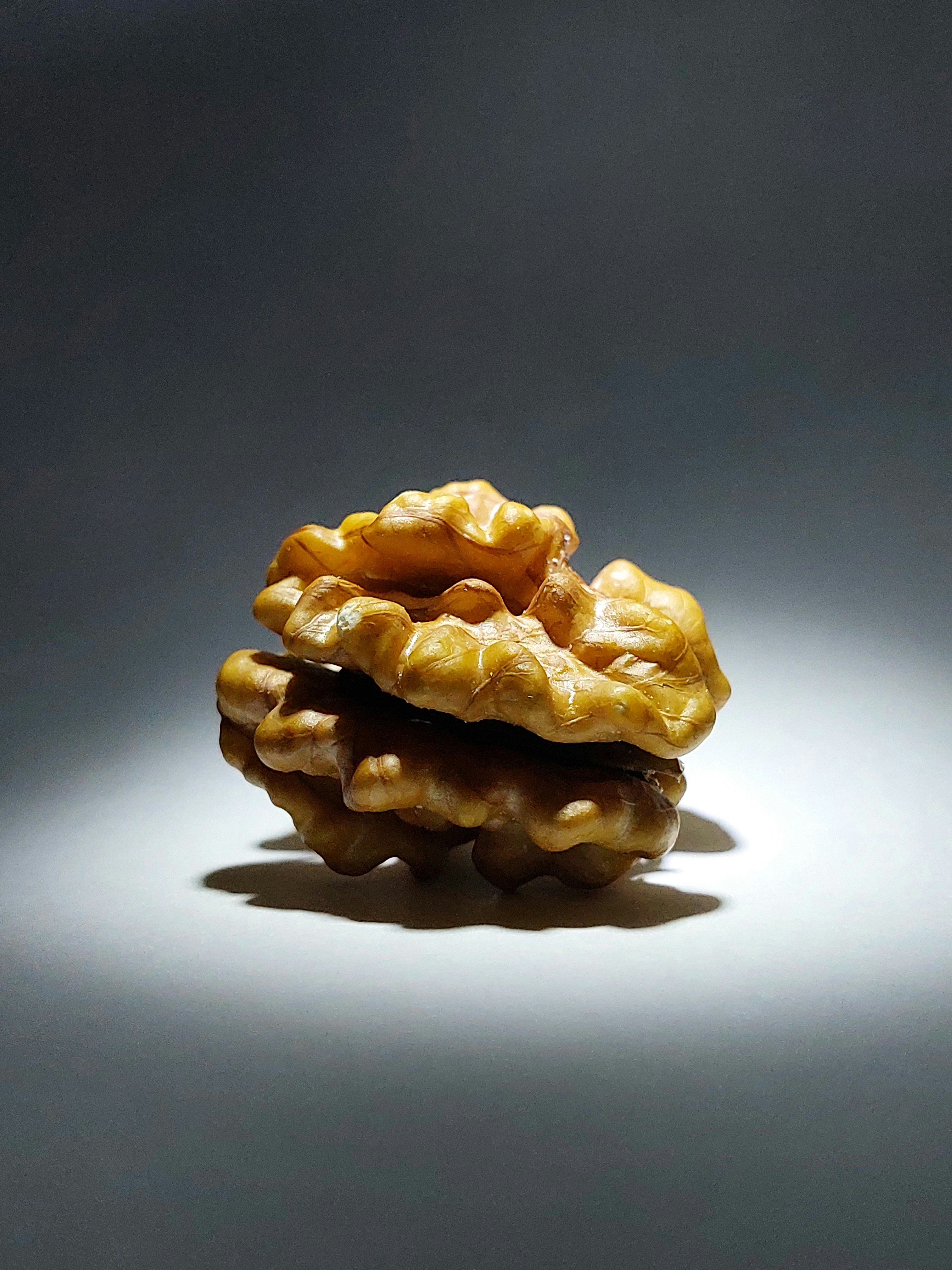 Walnut halves on a bright white wooden surface under clean natural light