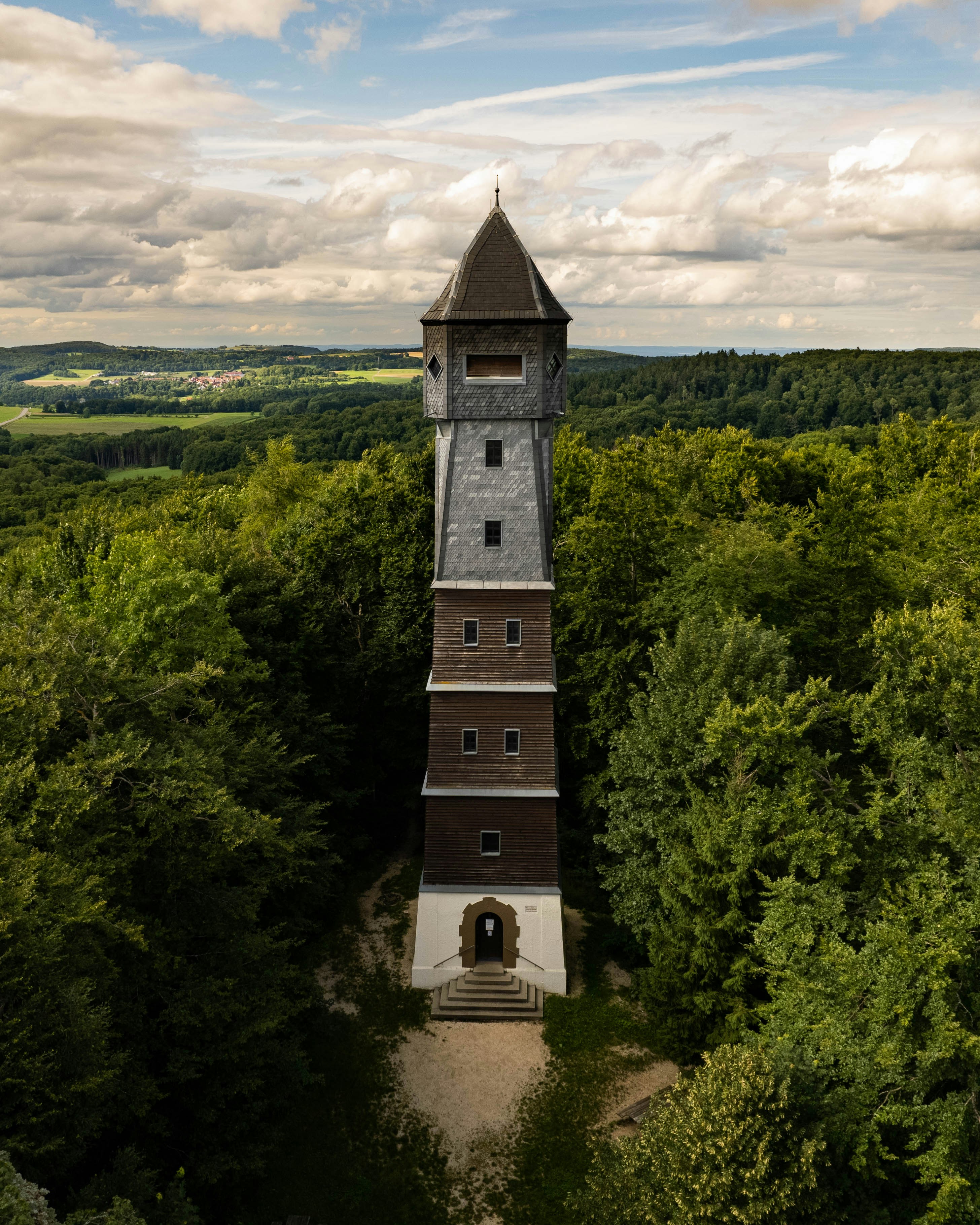 An aerial view of a tower in the middle of a forest