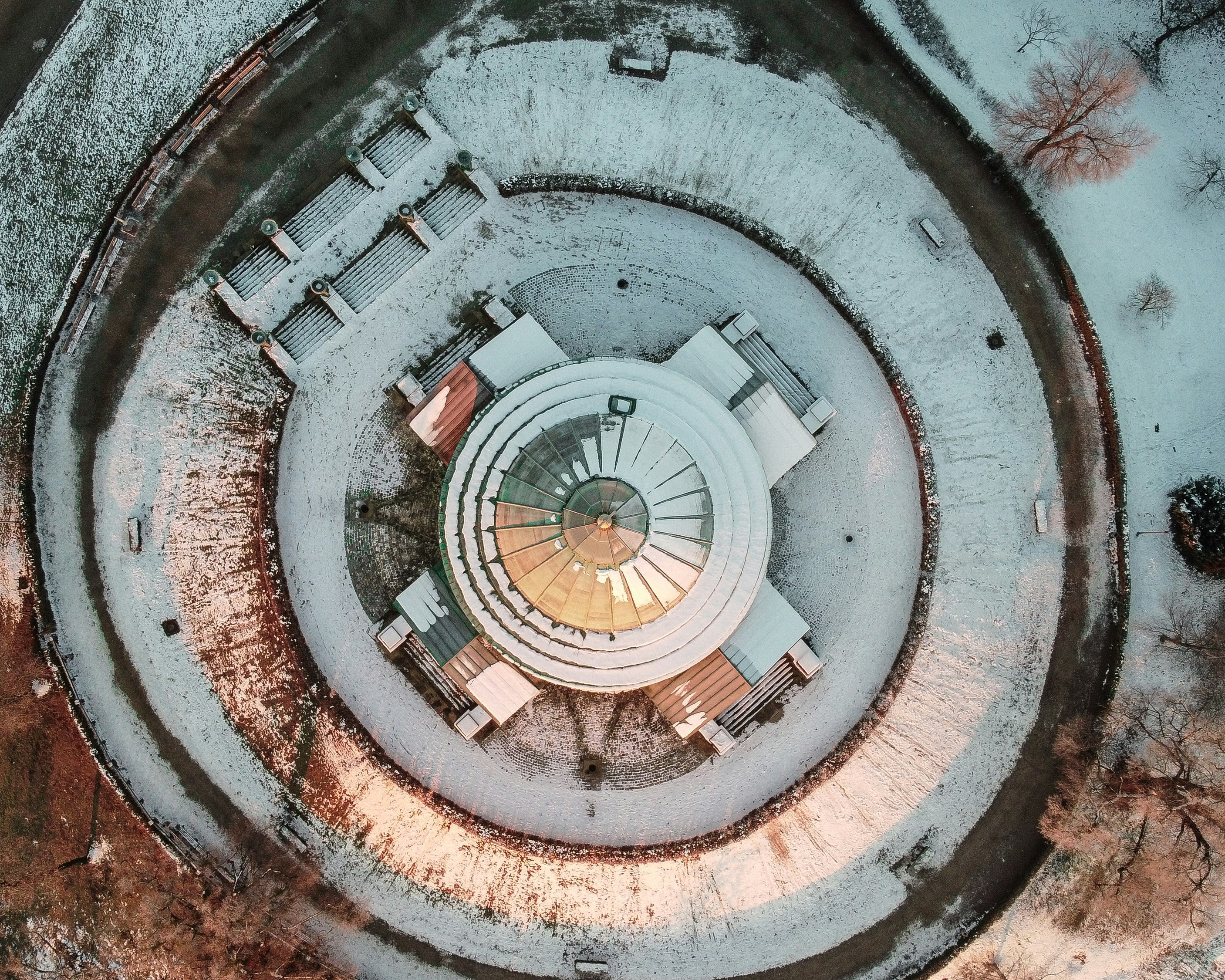 An aerial view of a circular building in the snow