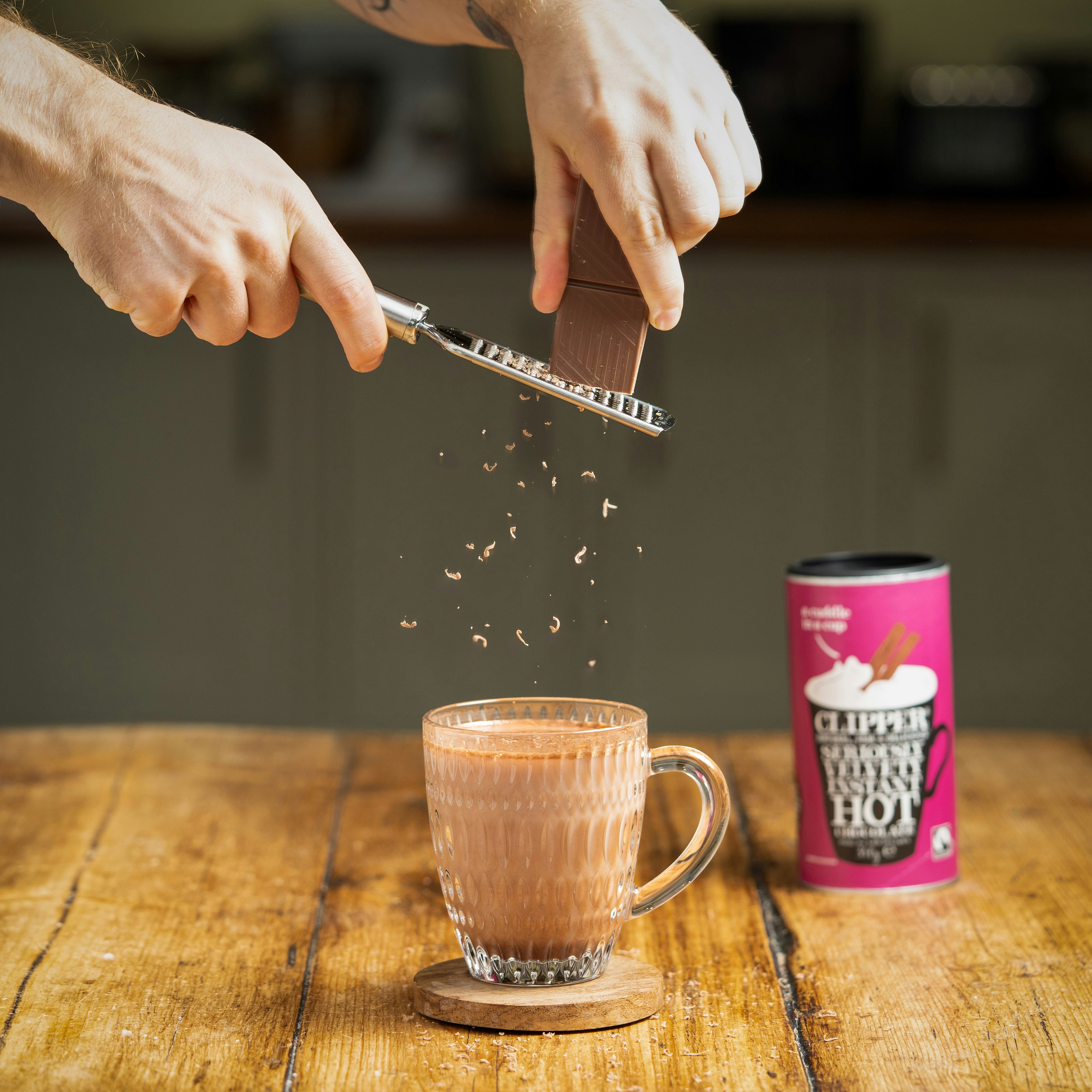 Eine Person, die Zucker in eine Tasse Kaffee schöpft