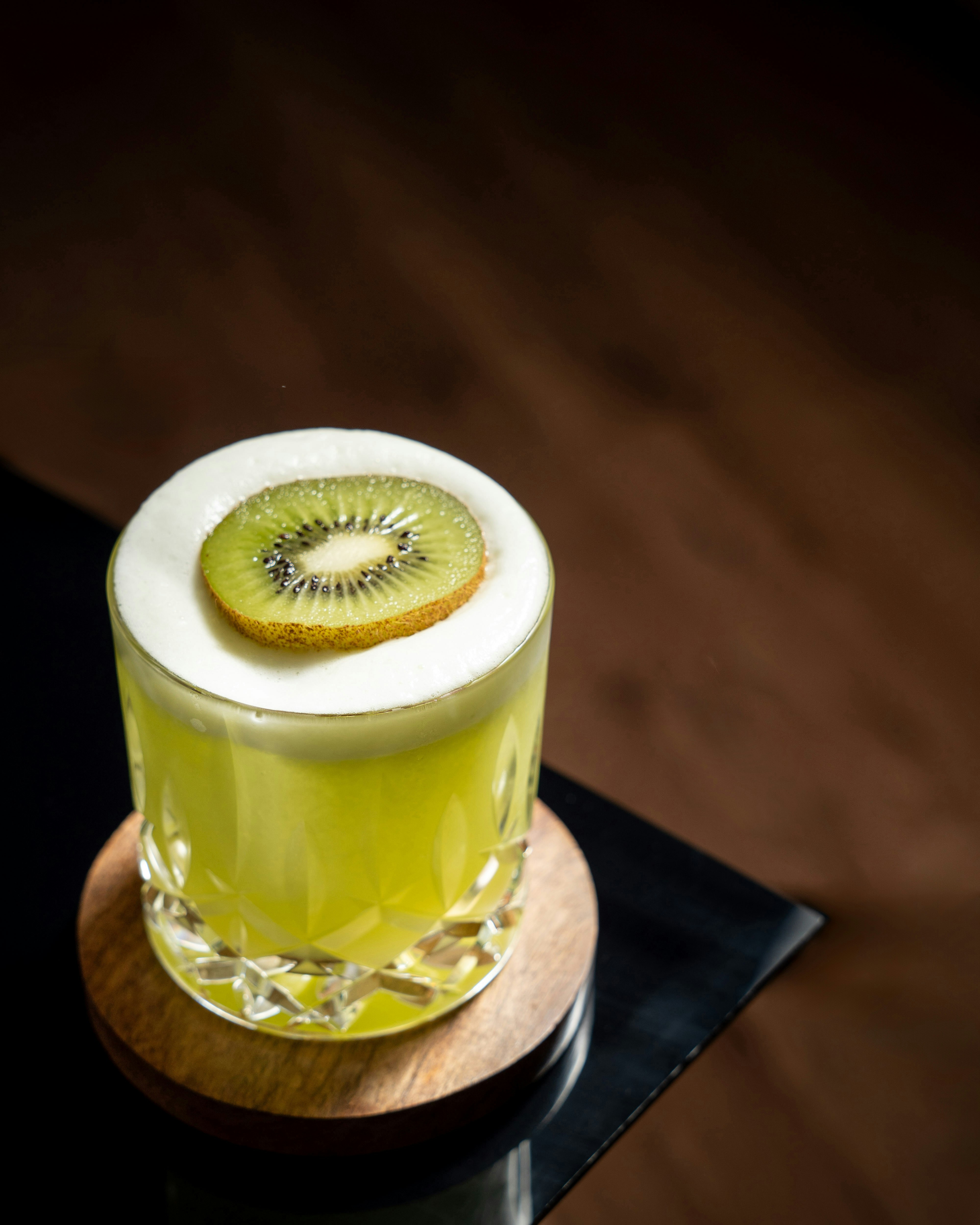 A kiwi fruit sitting on top of a wooden table