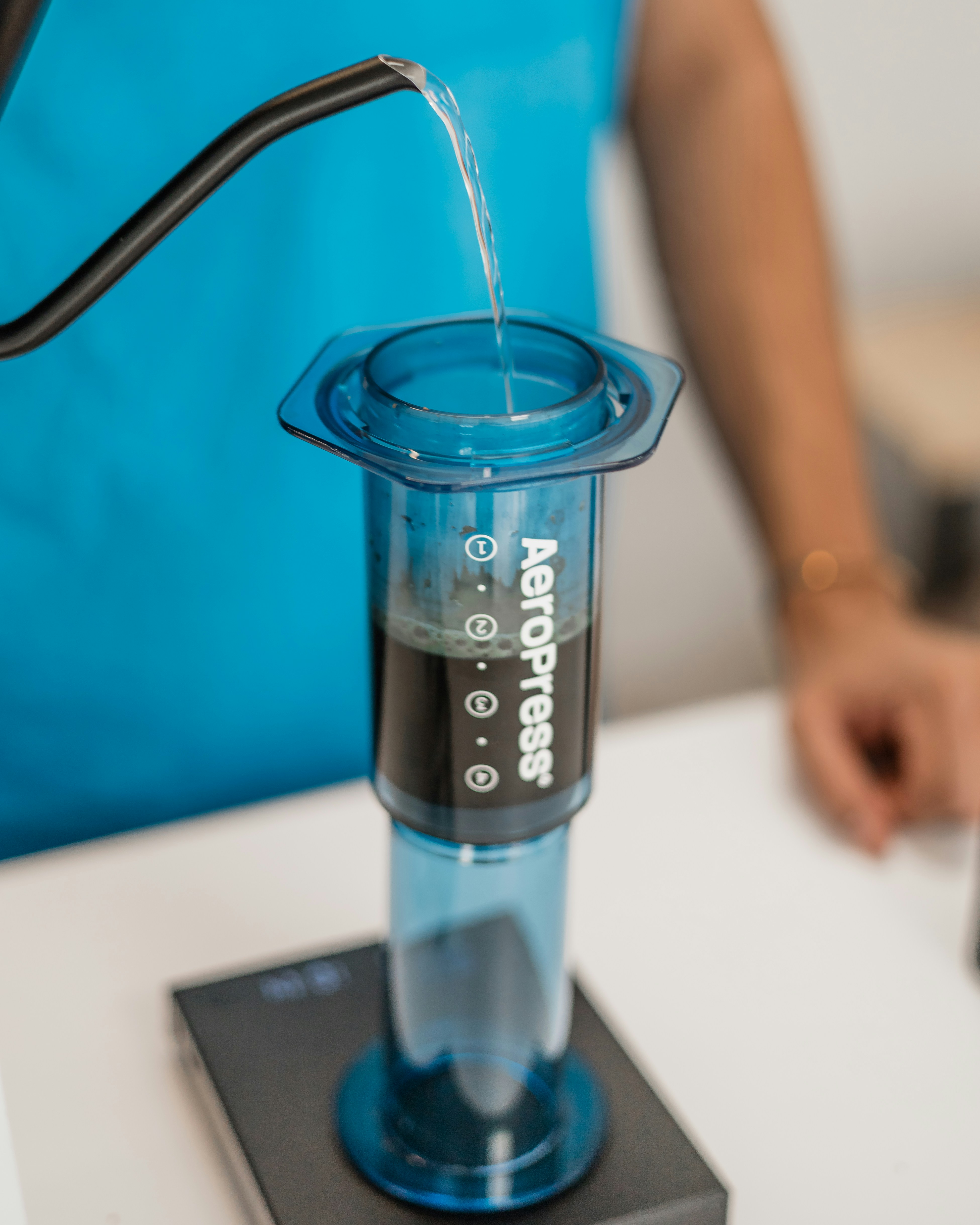 A person pouring a liquid into a beakle