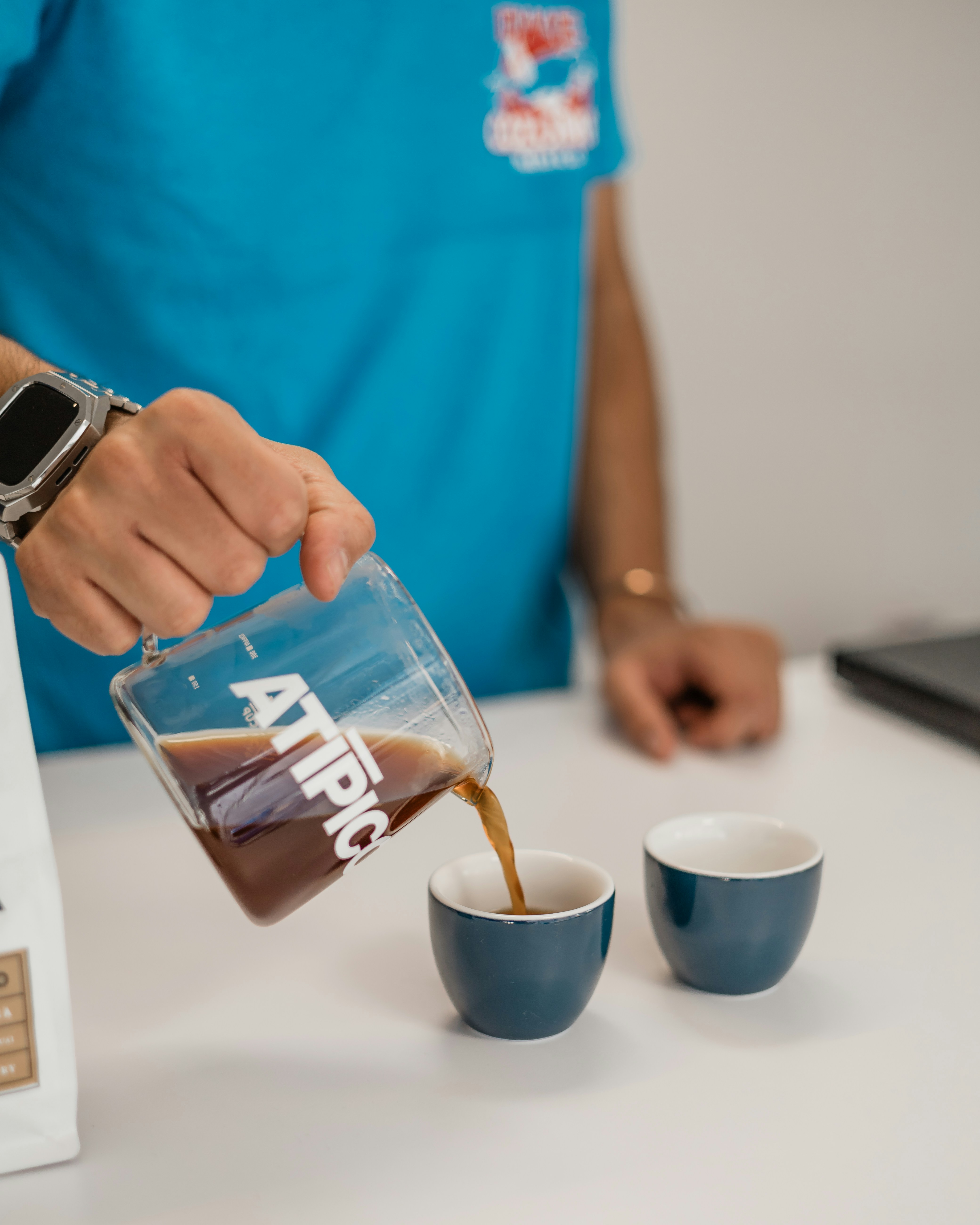 A man pours coffee into two cups