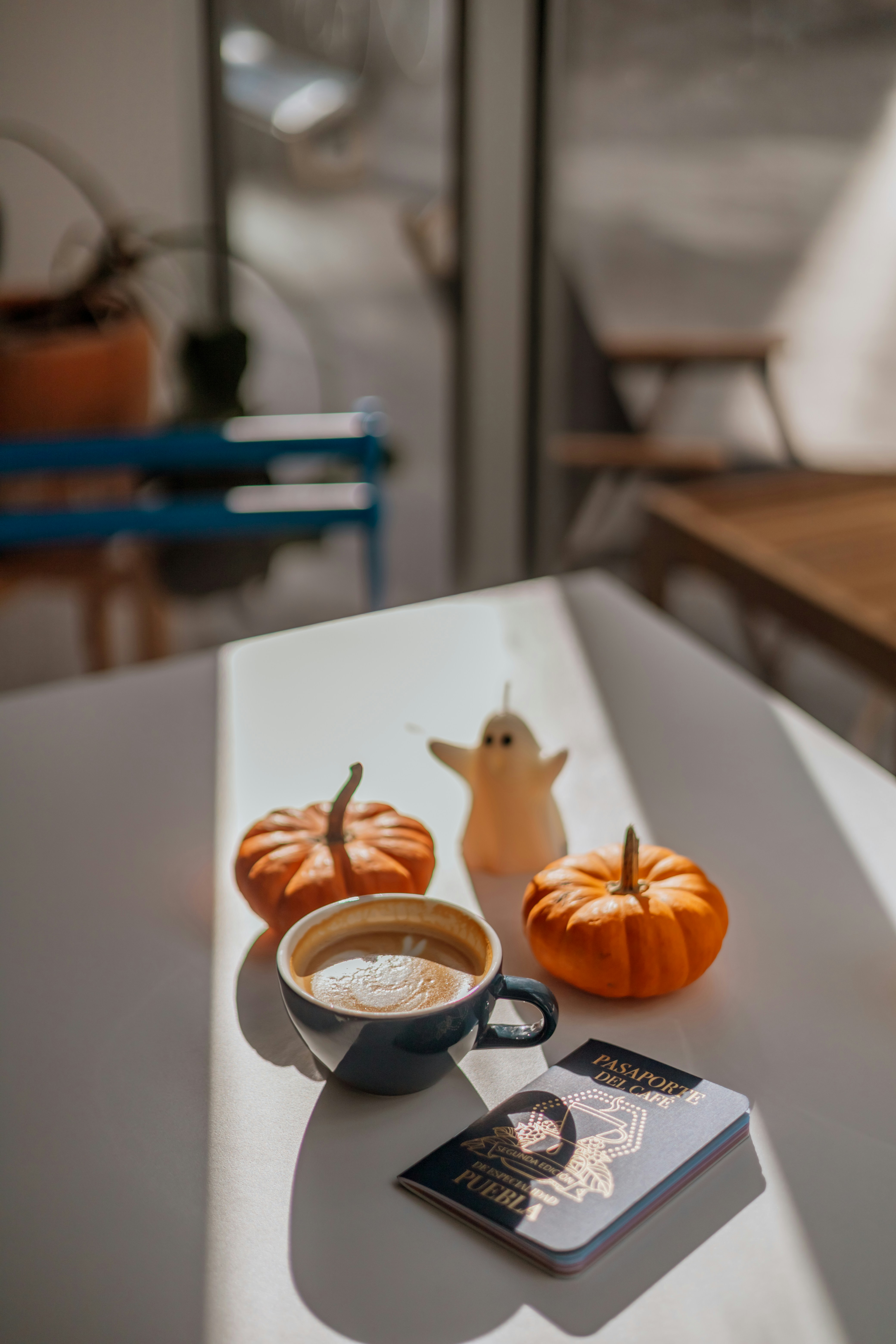 A cup of coffee sitting on top of a table next to a book