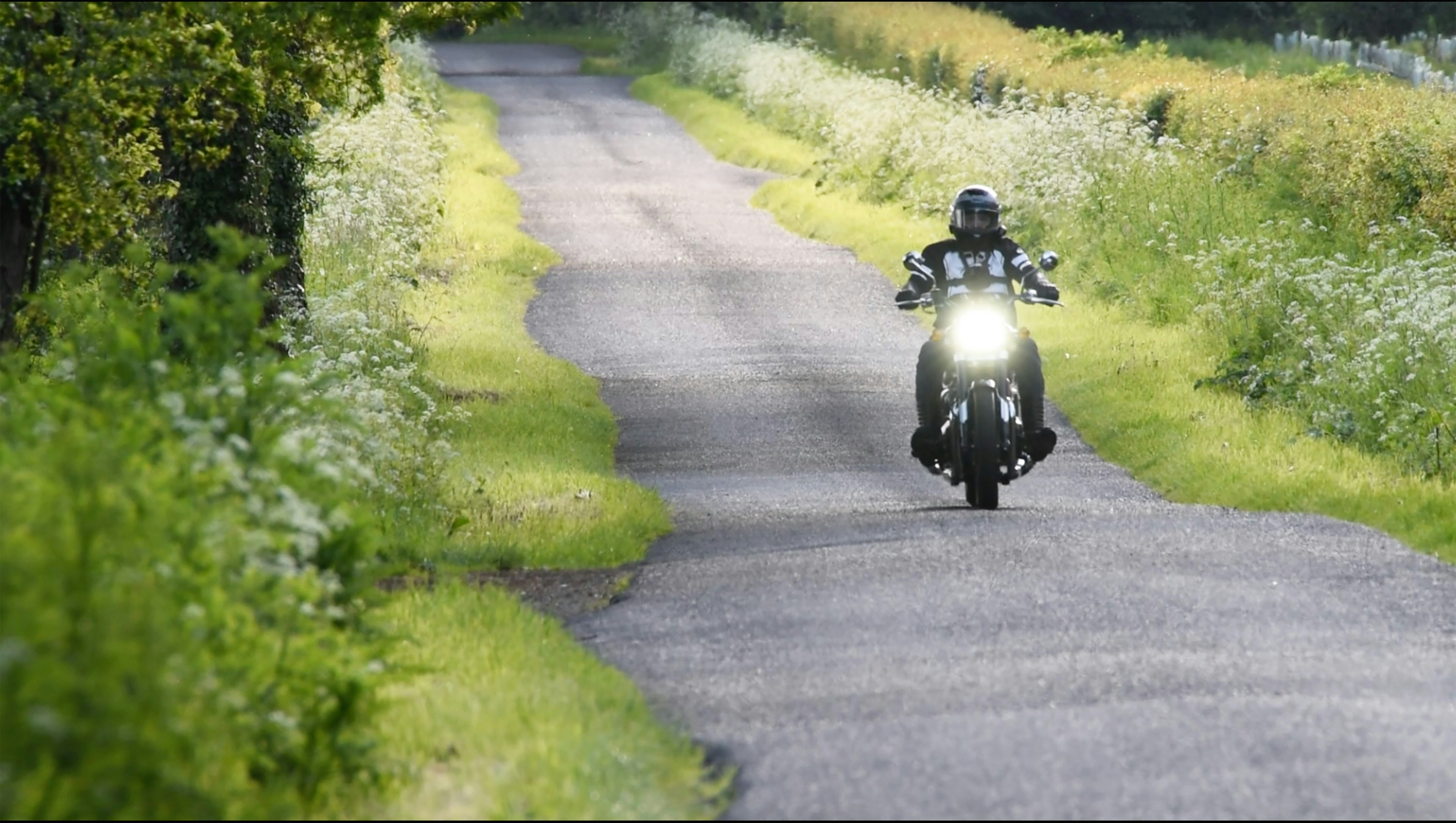 A man riding a motorcycle down a curvy road