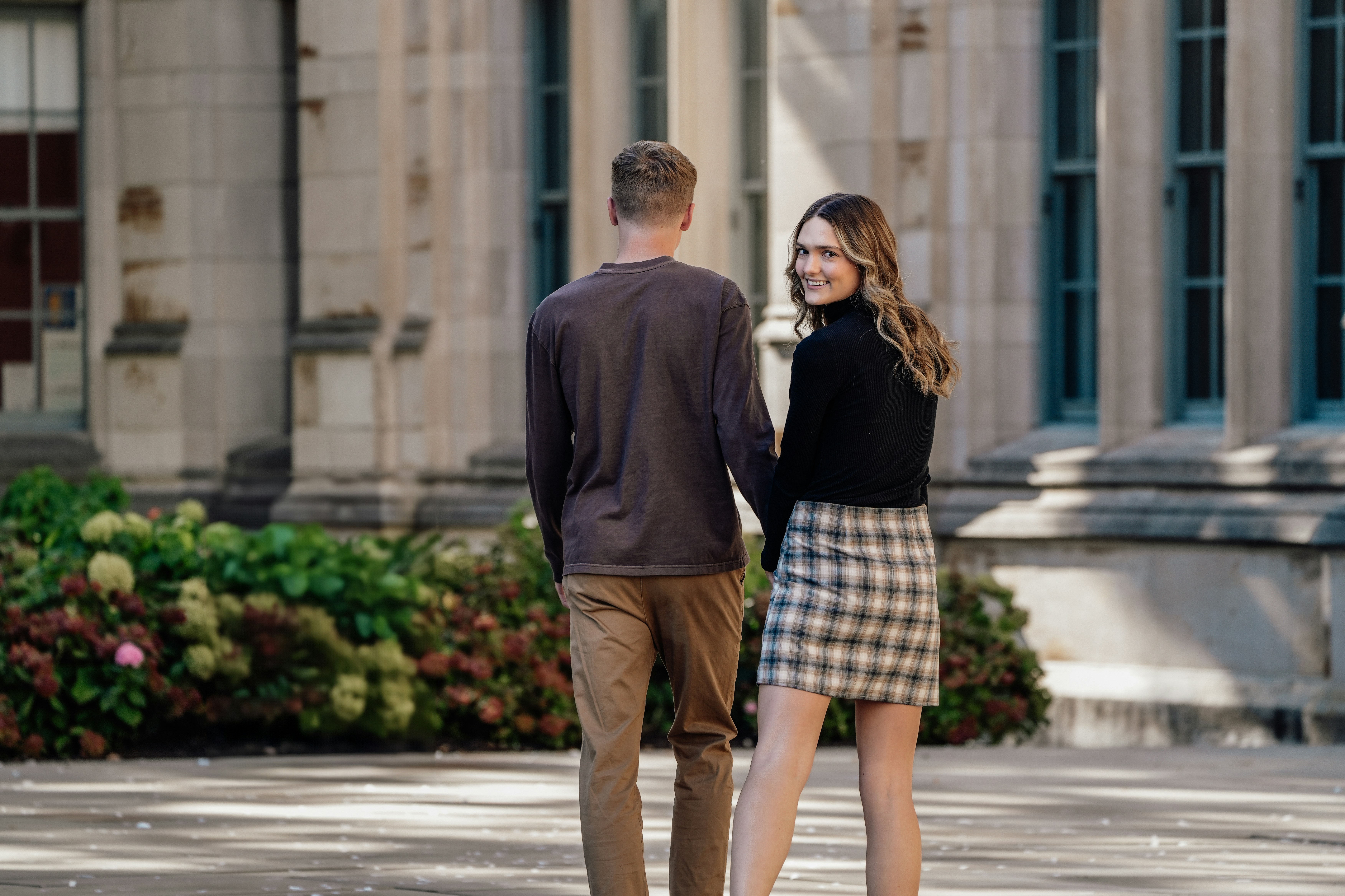 A man and a woman standing in front of a building