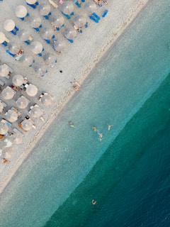 An aerial view of a beach with umbrellas and chairs