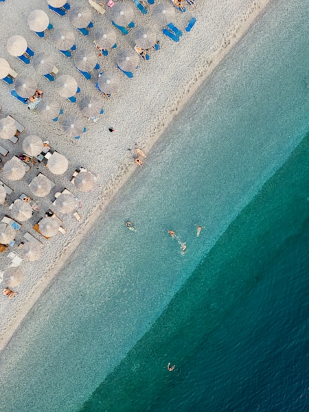 An aerial view of a beach with umbrellas and chairs