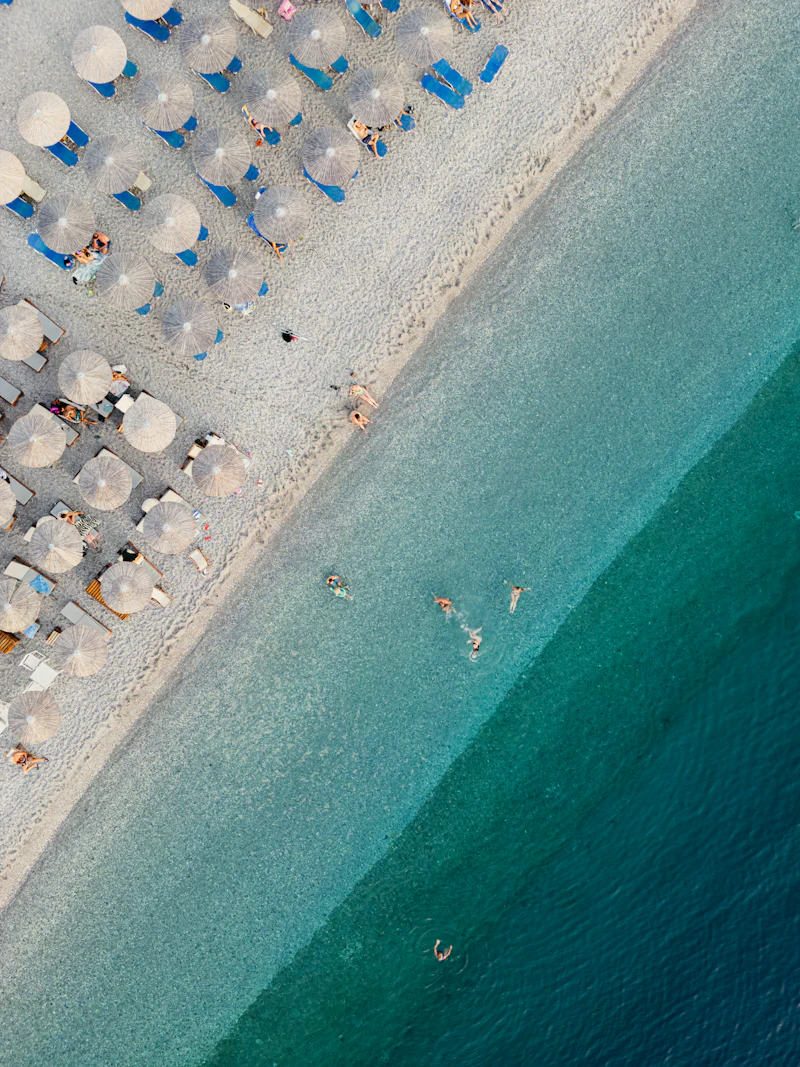 Aerial view of beach umbrellas along turquoise water