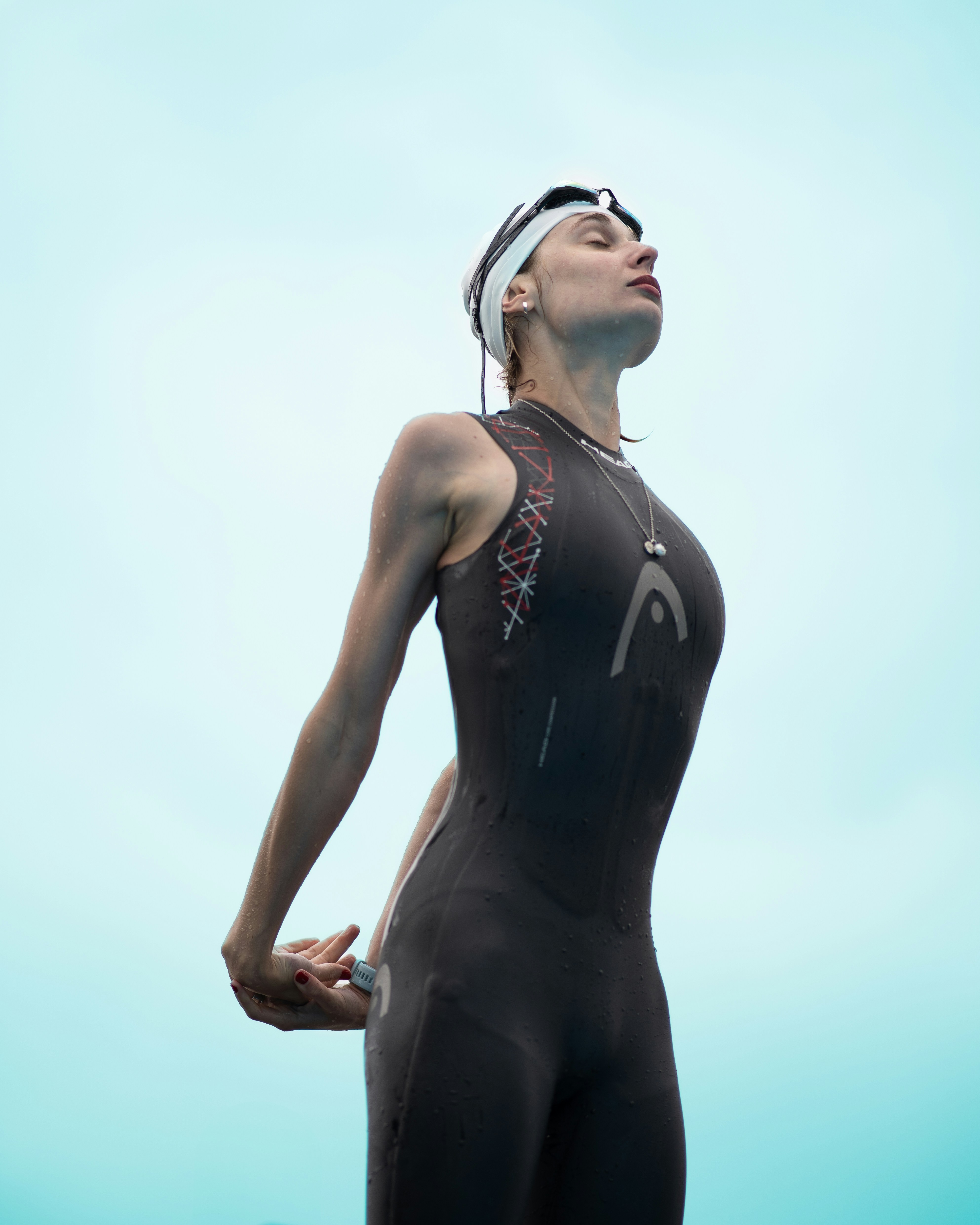 A woman in a wet suit is looking up