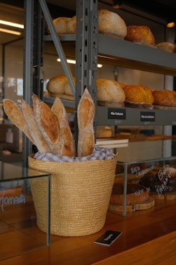 A basket filled with bread sitting on top of a wooden counter