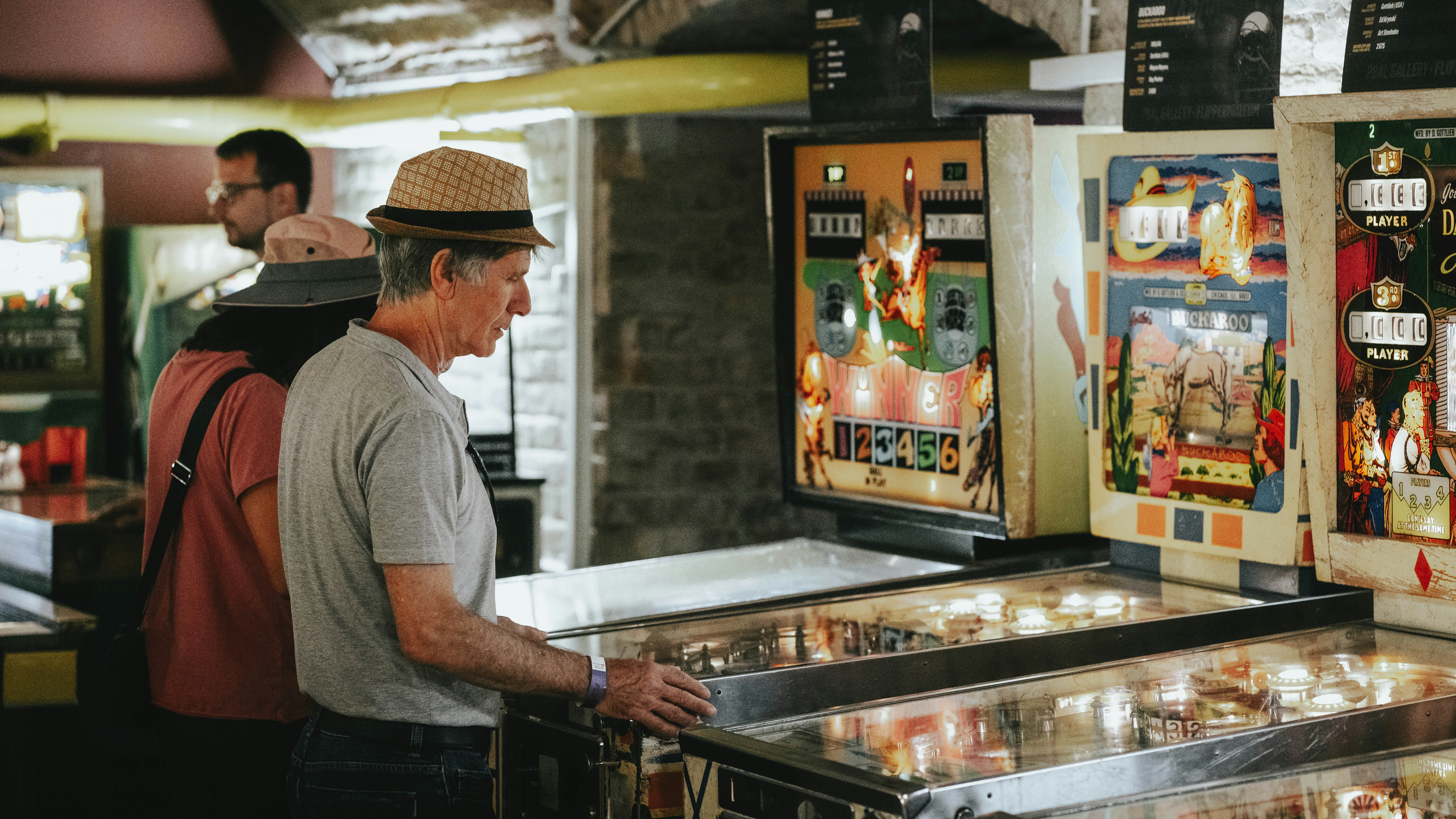 A man standing in front of a row of pinball machines