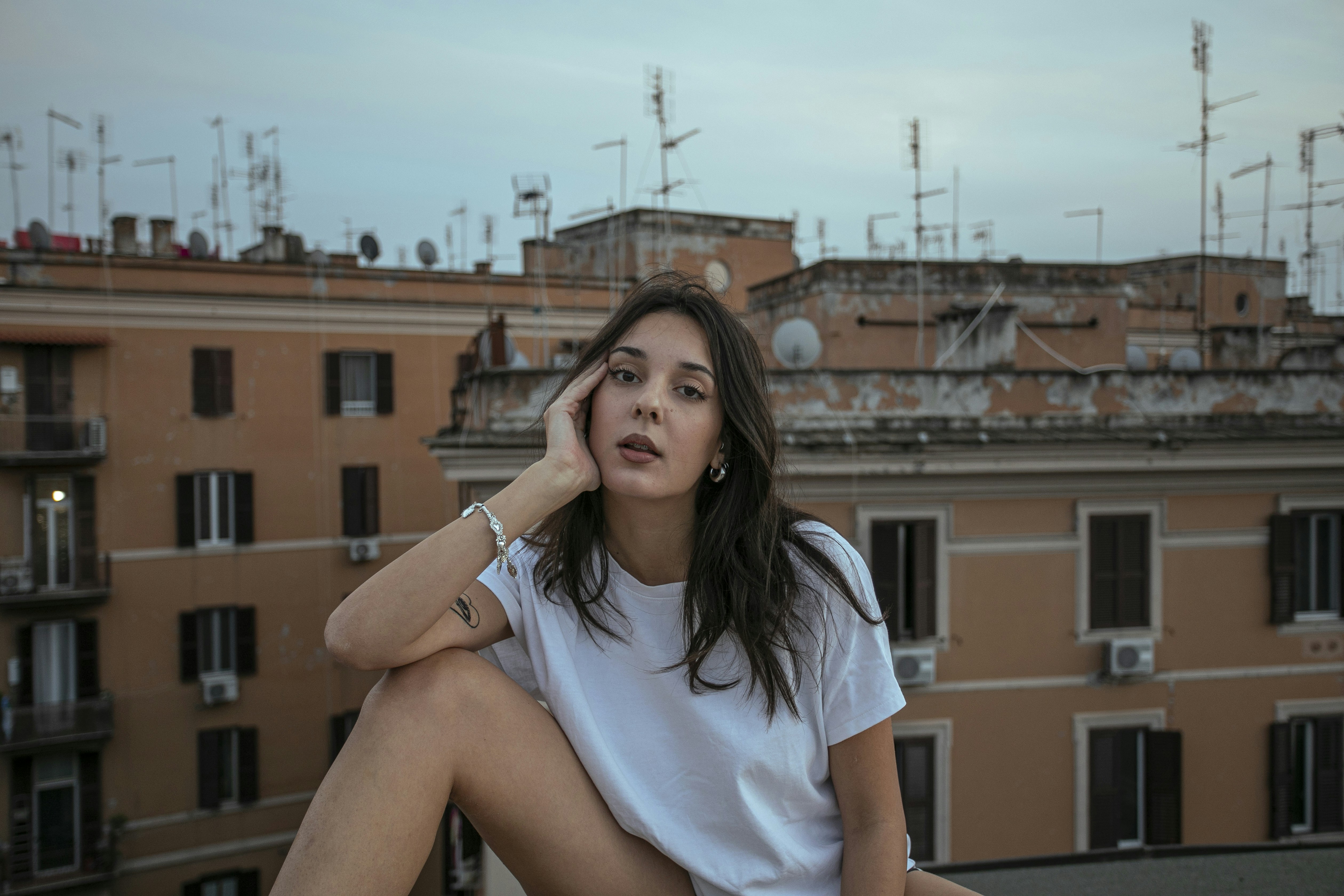 A woman sitting on a ledge in front of a building