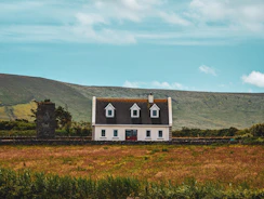 A white house sitting on top of a lush green field