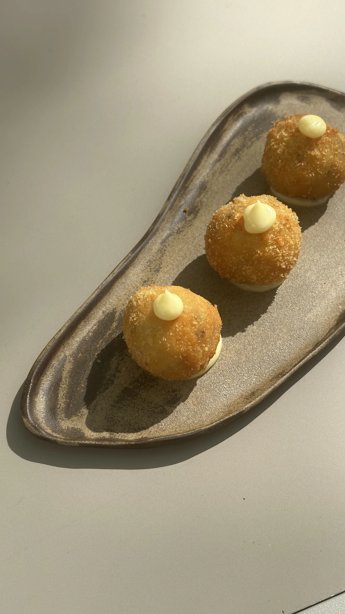Three small pastries on a plate on a cafe table