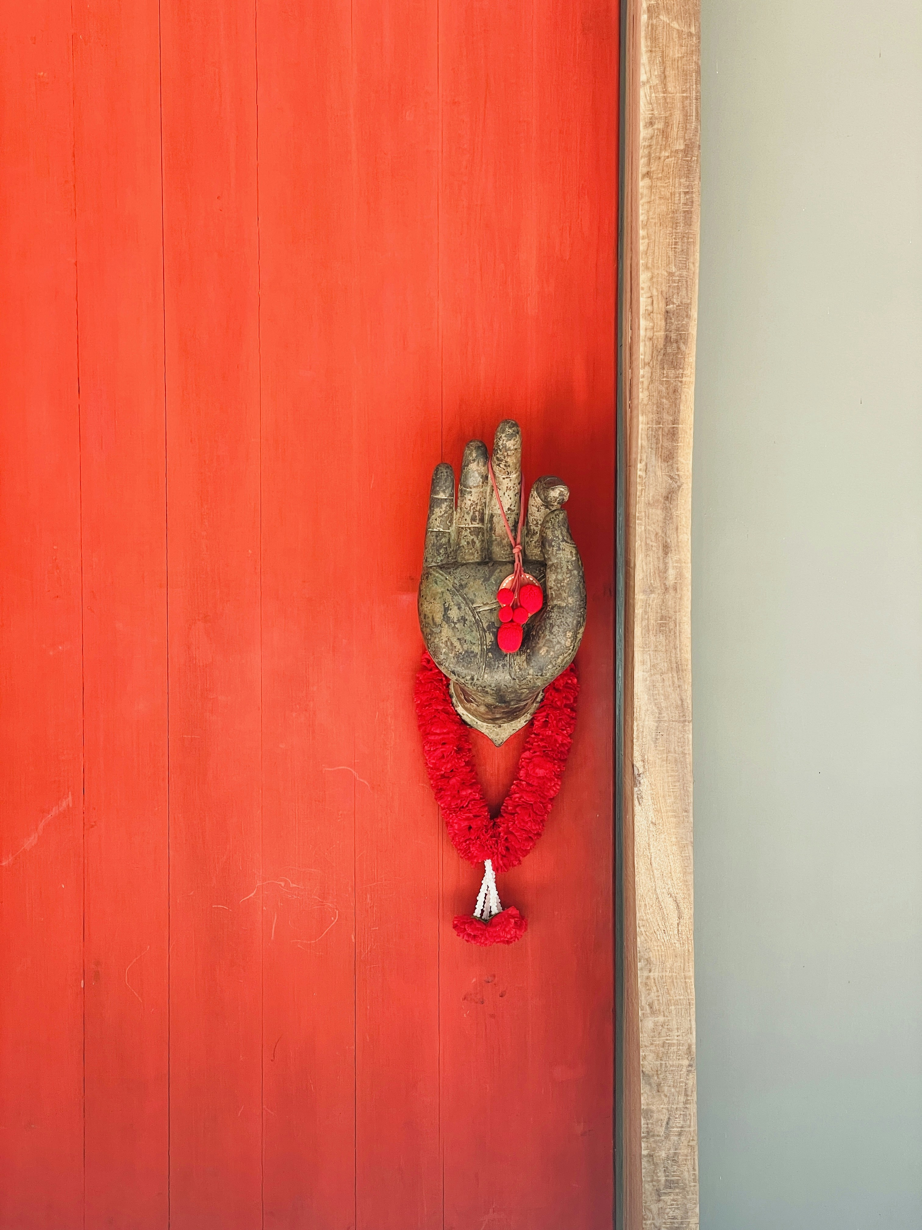 A red door with a hand holding a red object