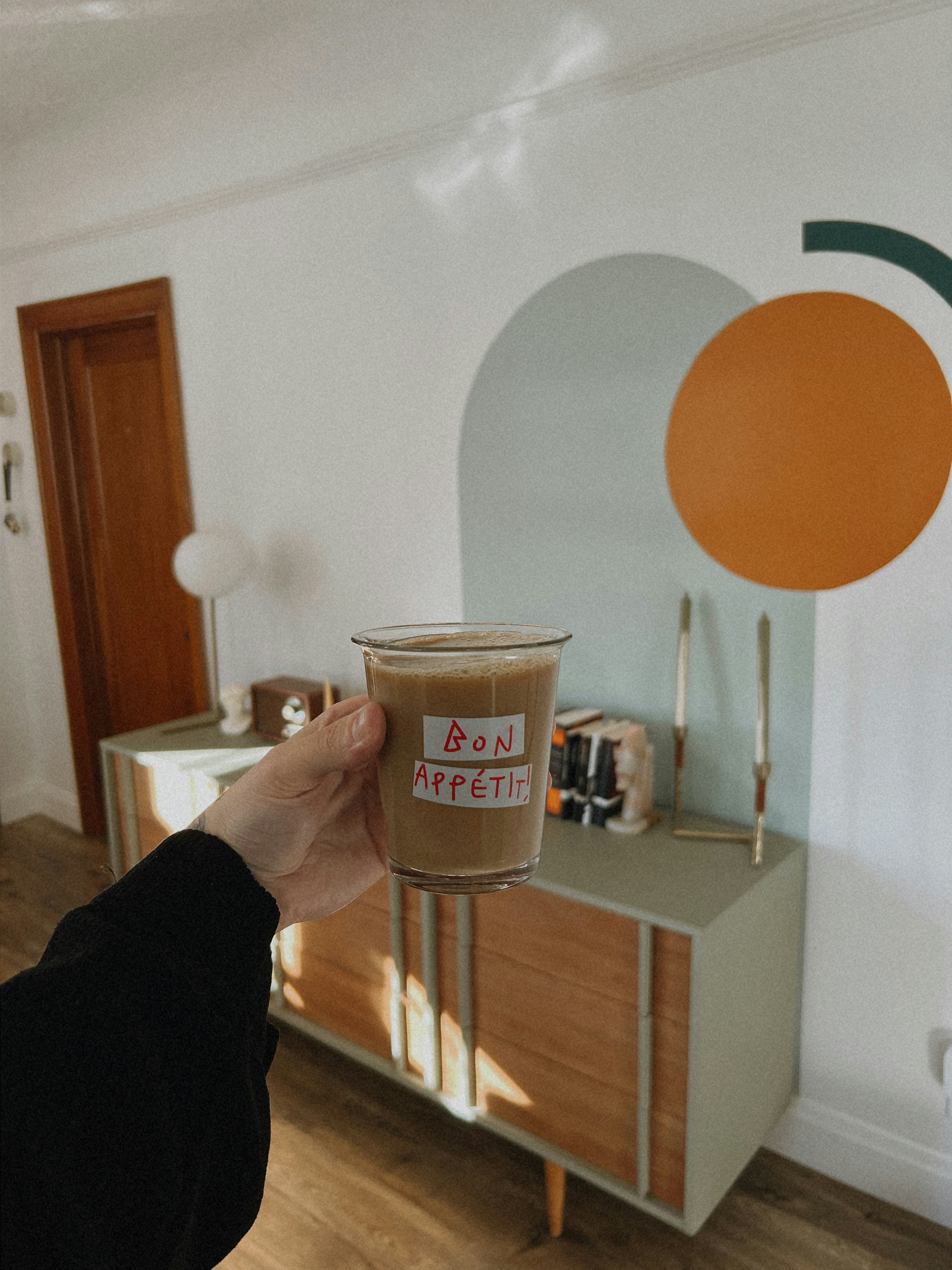 A person holding a cup of coffee in their hand