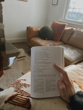 A person sitting on a couch reading a book