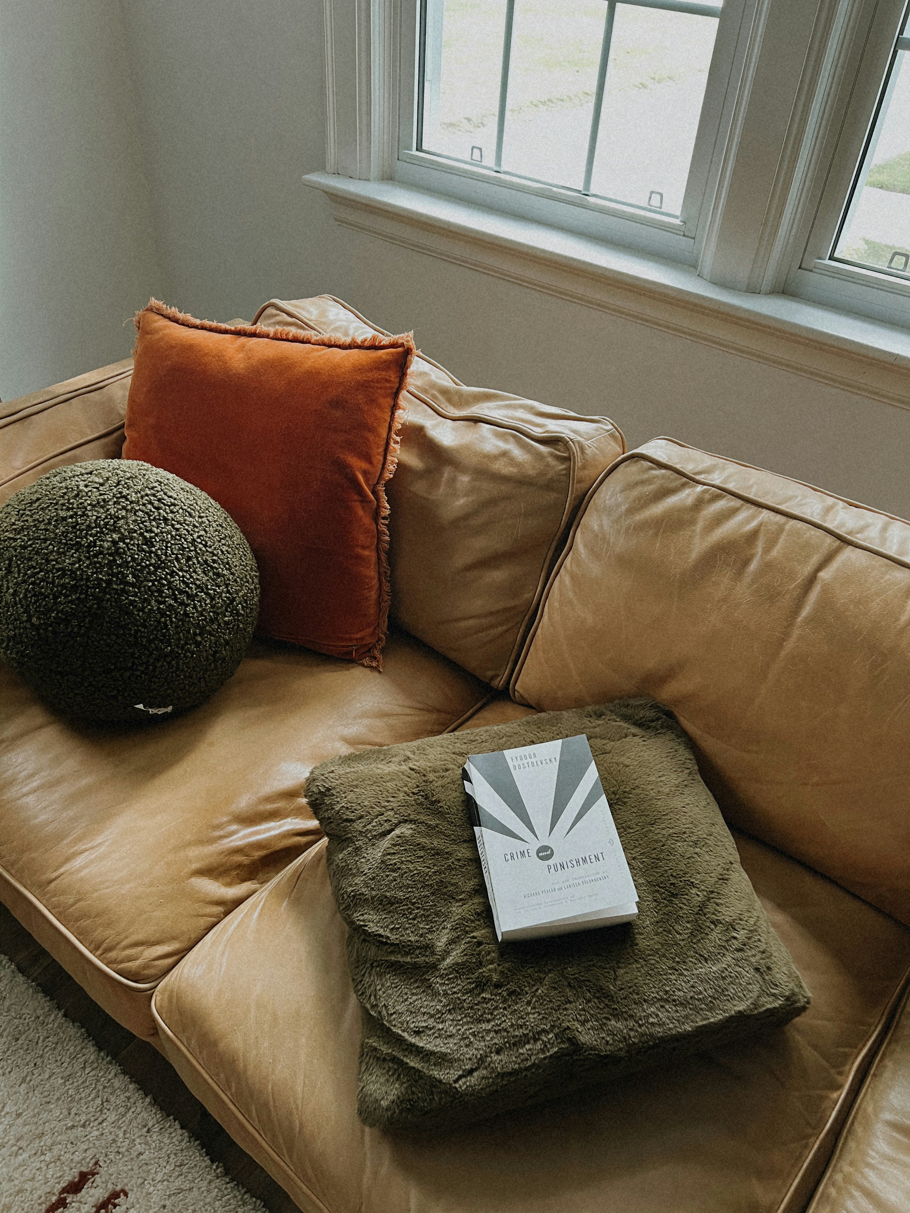 A couch with pillows and a book on it
